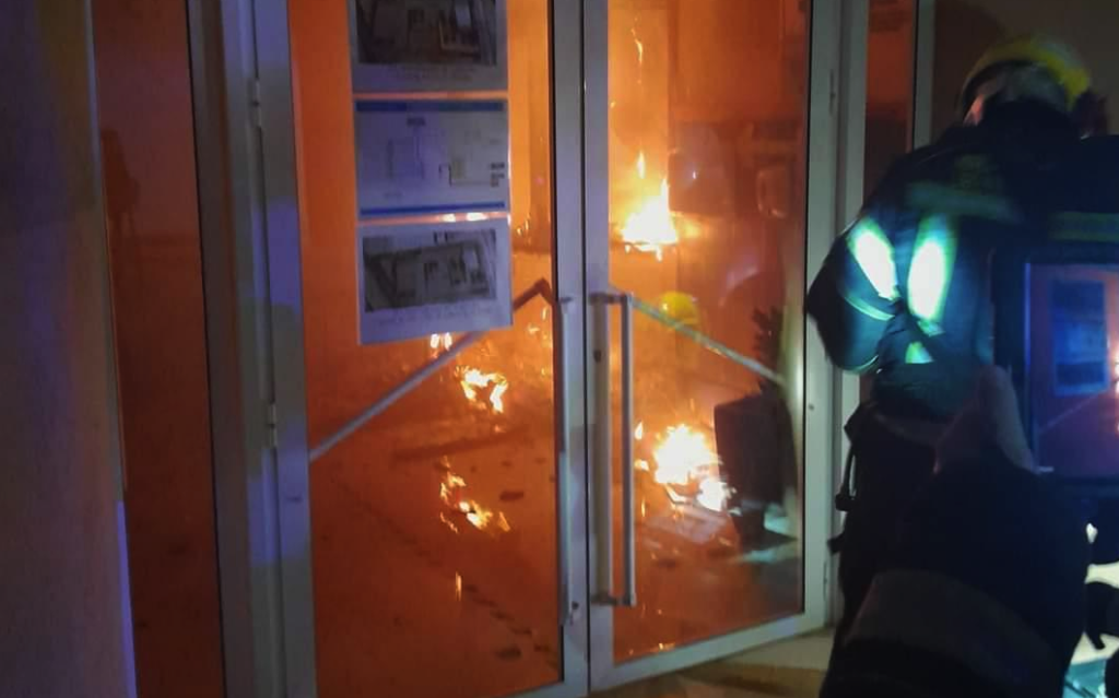 Un bombero luchando contra las llamas en el incendio provocado en un instituto de Almería.