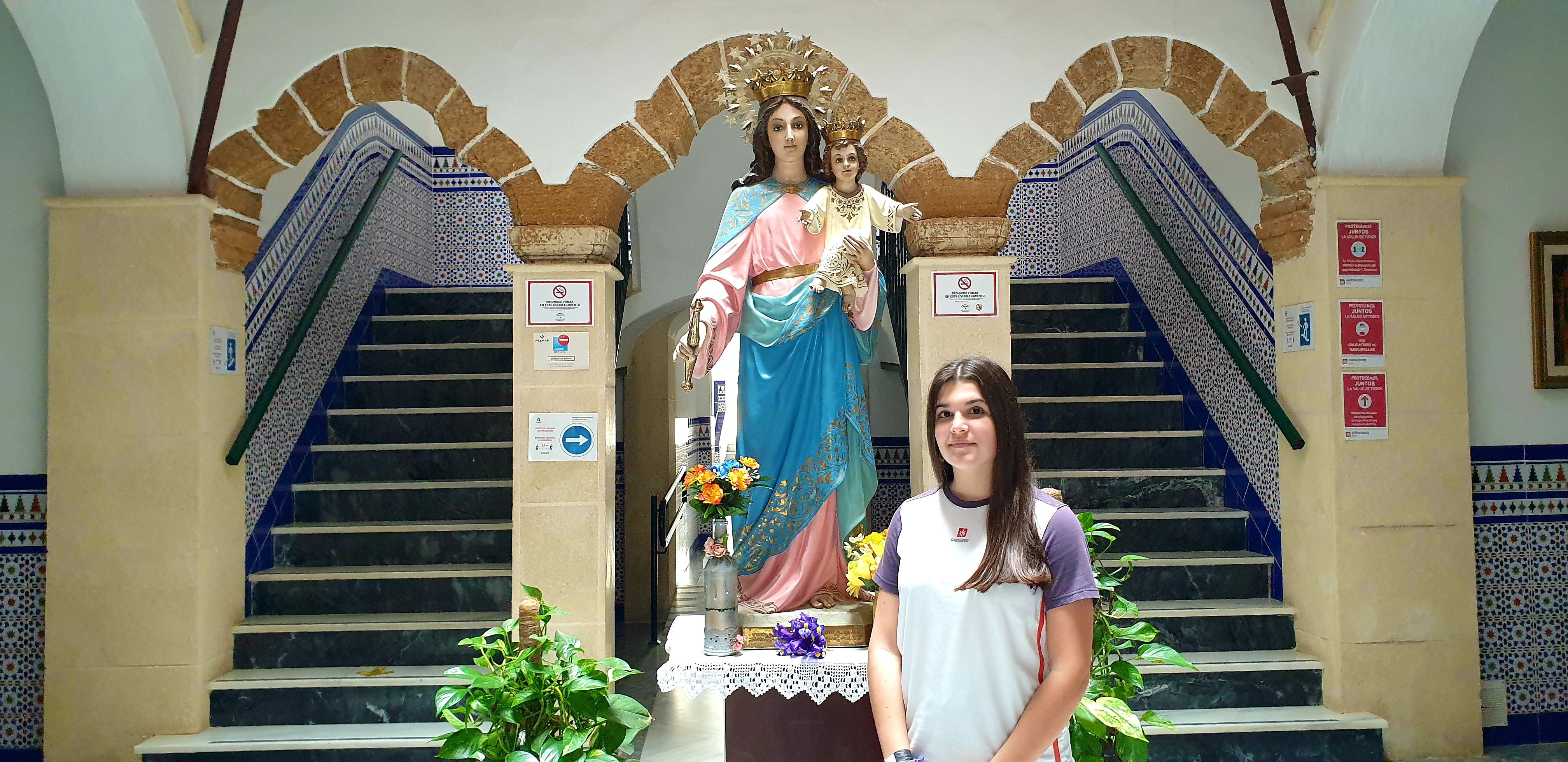La estudiante roteña Julia Bernal en la entrada del colegio Salesianos de Rota junto a María Auxiliadora.