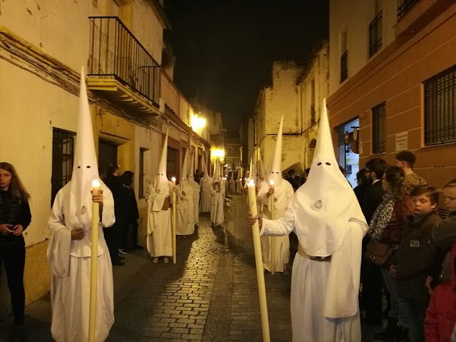 Nazarenos de Las Cinco Llagas con sus túnicas blancas y cinturón de esparto.