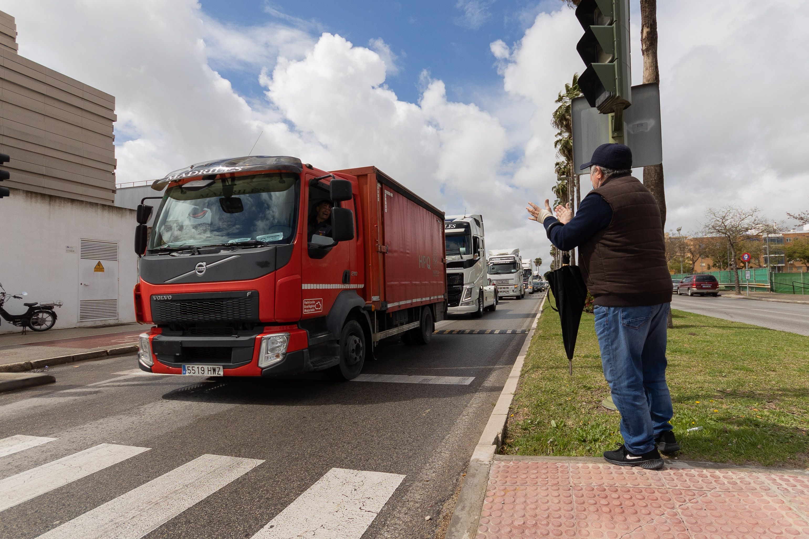Un hombre aplaude a camioneros que secundan el paro del transporte.