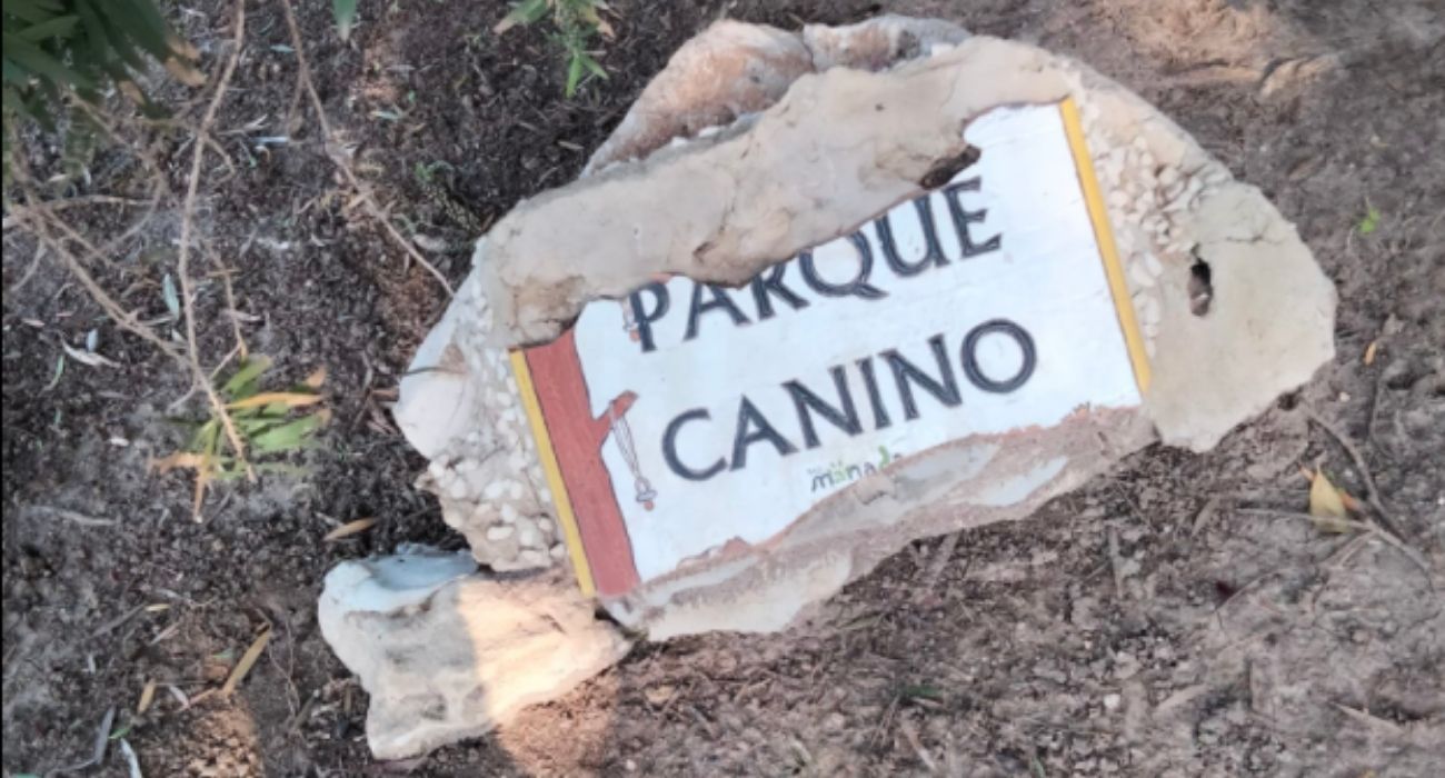 La placa del parque canino de Palos Blancos, tirada en el suelo.