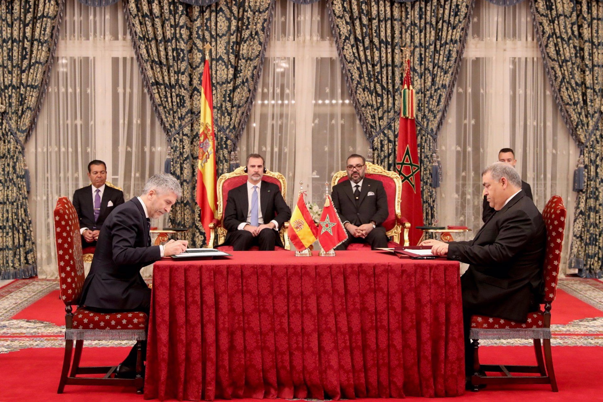 El Rey Felipe VI y el Rey Mohamed VI, y en la mesa, el ministro del Interior, Fernando Grande-Marlaska (i), durante la firma del Convenio bilateral en materia de Lucha contra la Delincuencia entre los Ministerios de Interior.