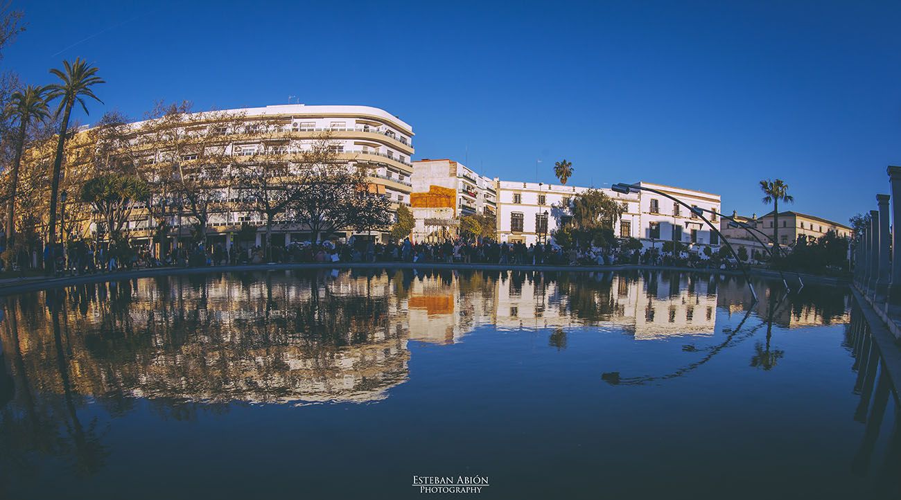 El Jerez cofrade se despereza, nace un nuevo día. Imagen panorámica del lago del Mamelón mientras una cofradía entra en Eguiluz para acceder al Palquillo.