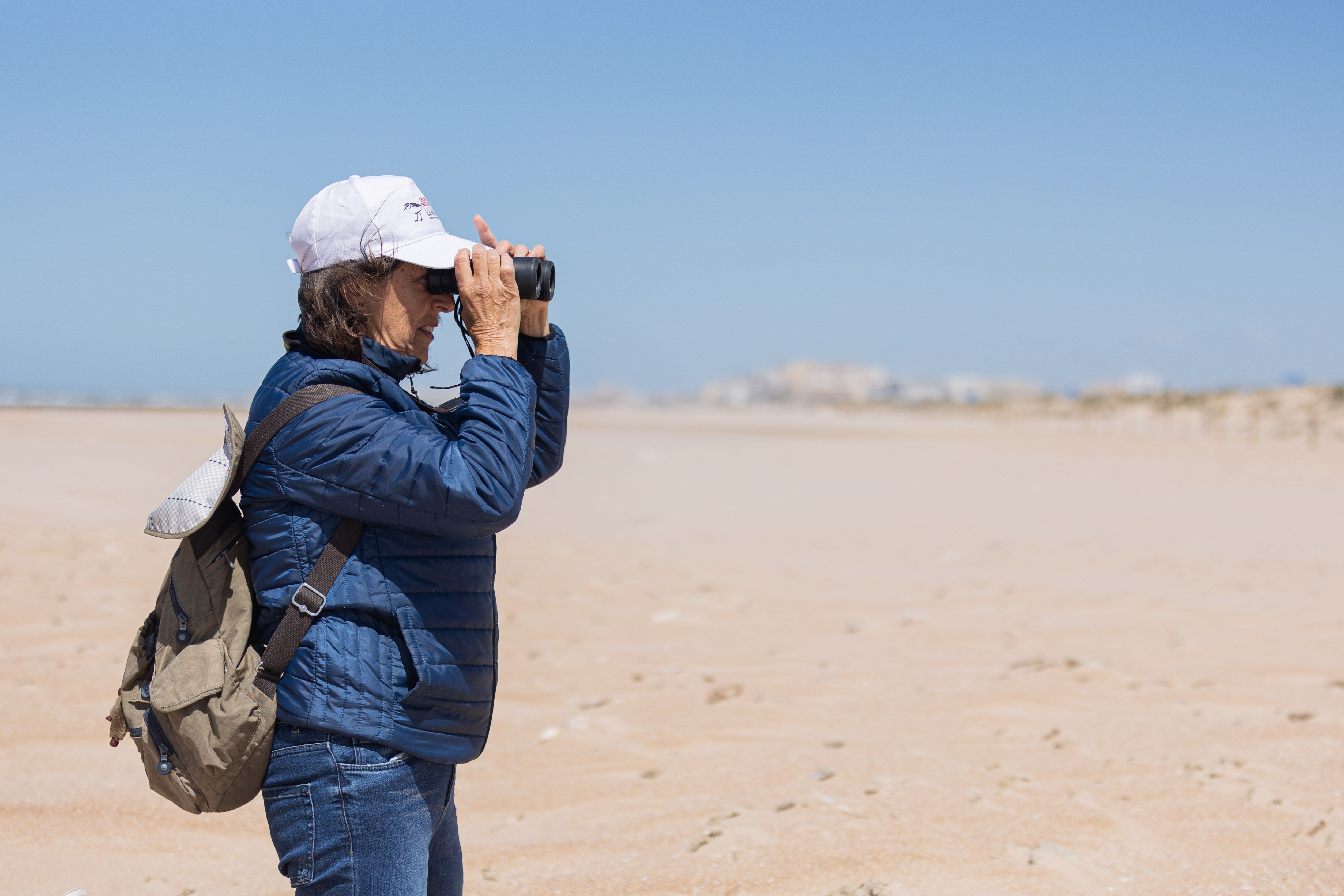 Paula Marchena, bióloga de Agaden, avistando Chorlitejos patinegros en la playa de Cortadura de Cádiz.
