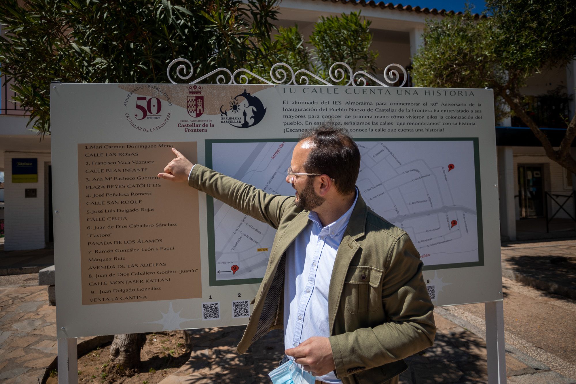 Adrián Vaca, alcalde de Castellar, muestra un panel colocado en la plaza Andalucía con motivo del 50 aniversario del pueblo.