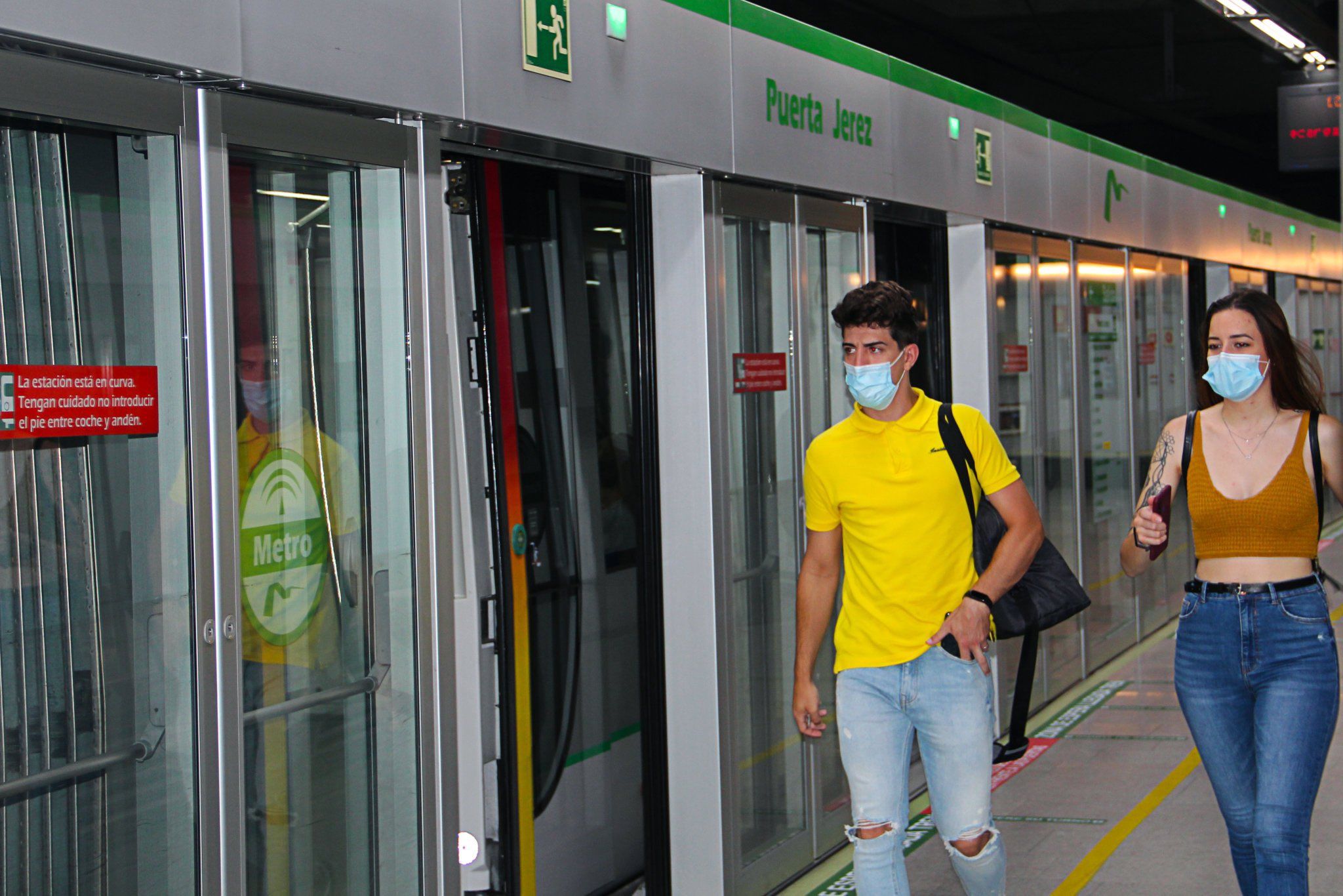 Dos pasajeros, preparados para subir al metro de Sevilla, uno de los transportes de la Junta con descuentos.