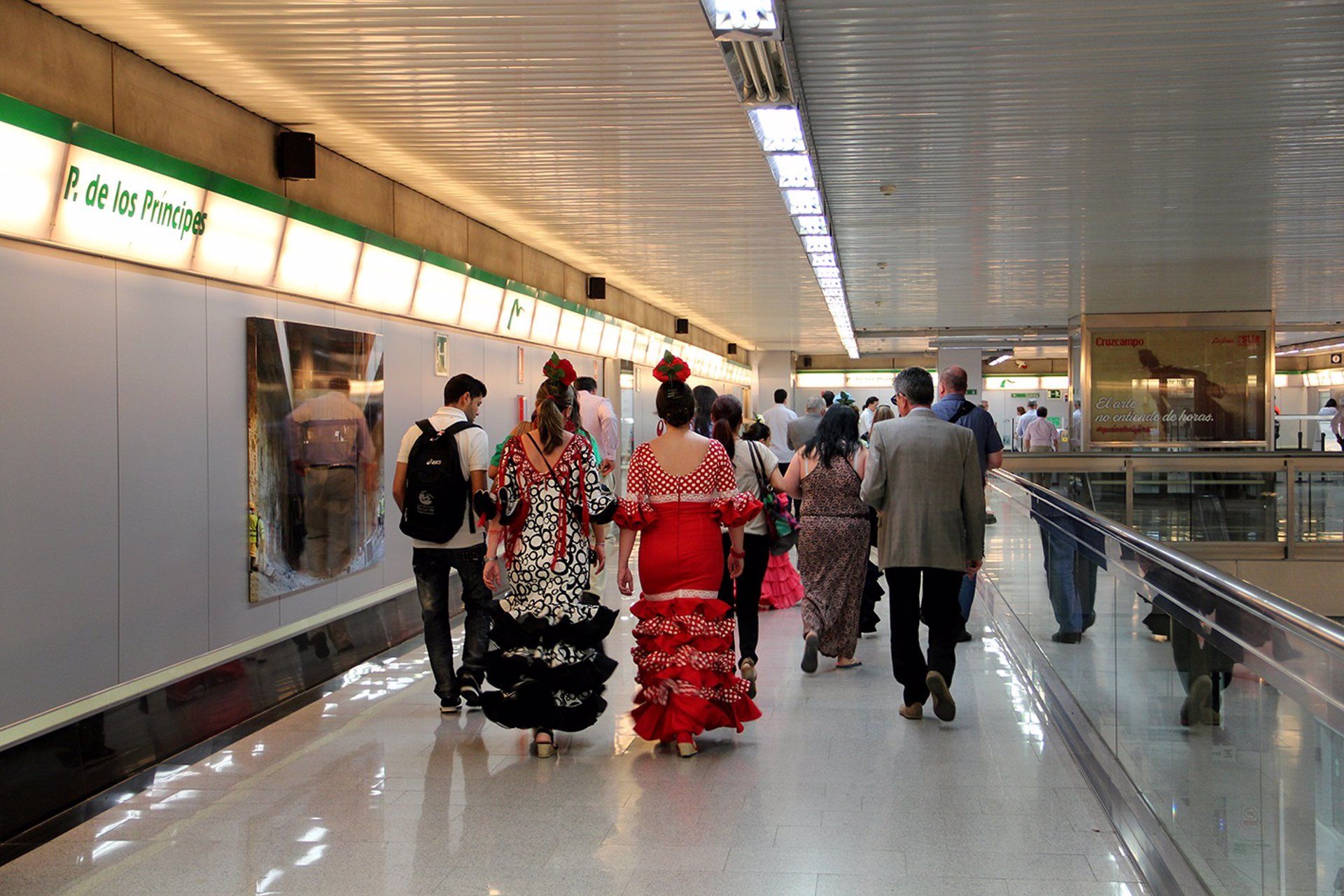  Mujeres vestidas de flamenca en una estación de Metro en Sevilla.