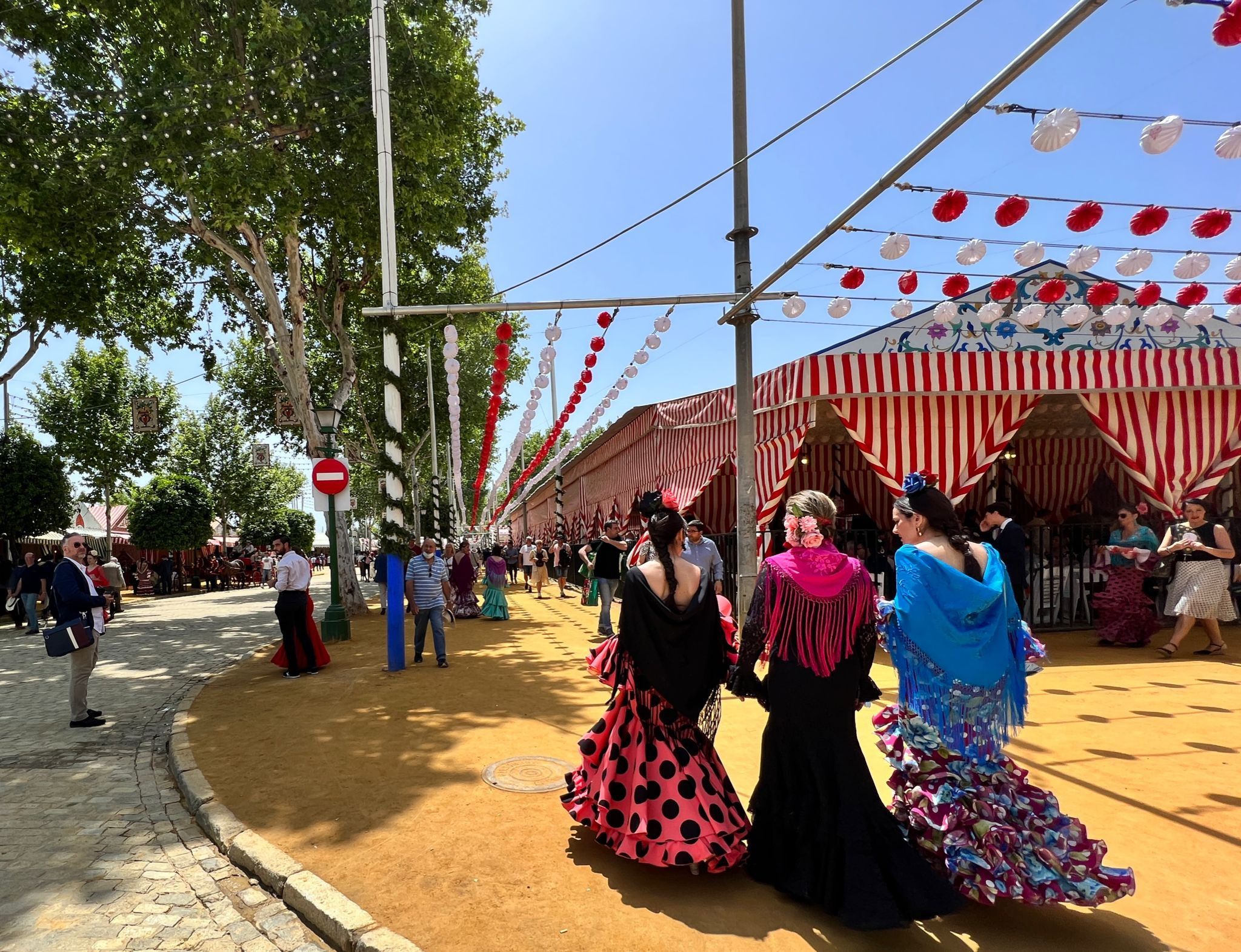Mujeres de flamencas caminan por el Real en una foto compartida por el Ayuntamiento de Sevilla.