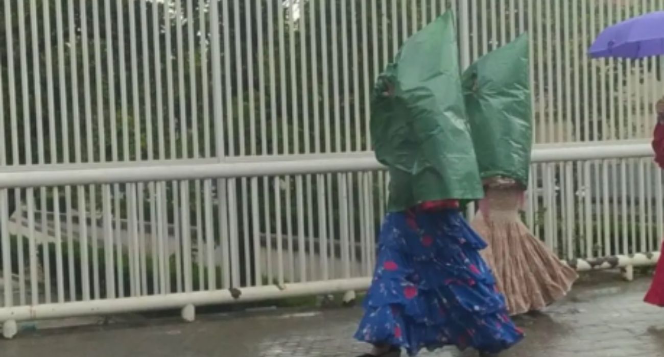 Las 'flamencas penitentes', tras la aparición de la lluvia en la Feria de Sevilla.