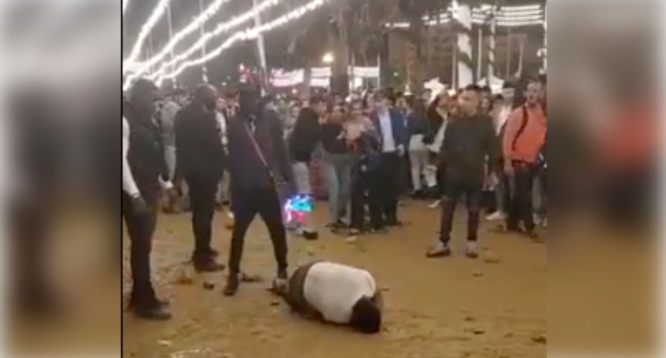 El joven agredido en la Feria de Abril en la puerta de la caseta del PSOE de Sevilla, tirado en el suelo.