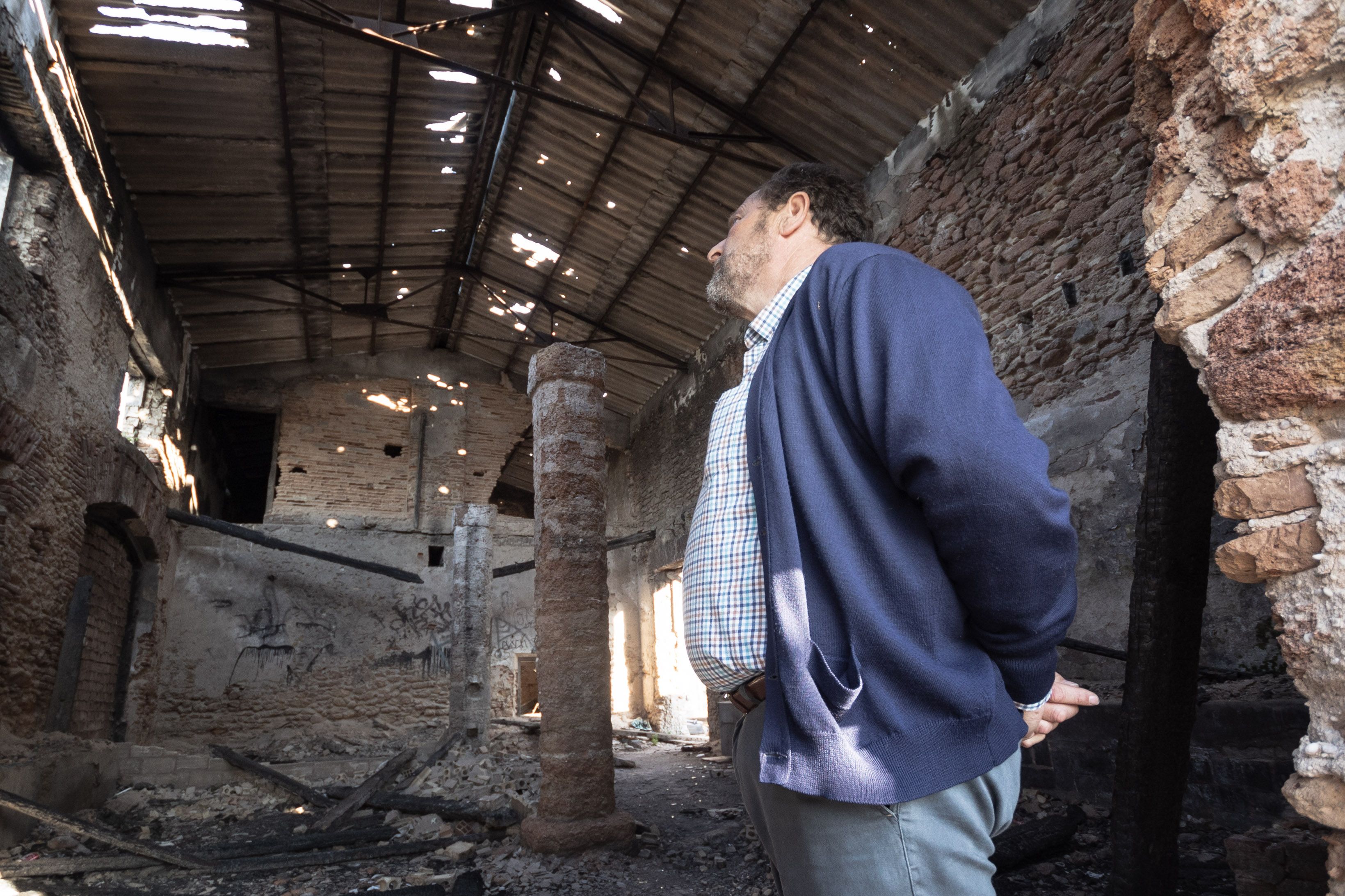 Emilio observa el edificio en ruinas.