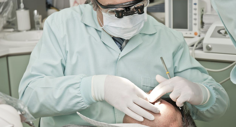 Un dentista, tratando a un paciente, en una imagen de archivo.