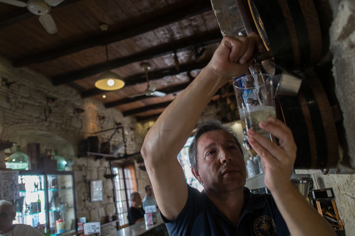 Luis Carlos López, propietario de la Abacería Cruz Vieja, sacando vino fino de una bota. FOTO: MANU GARCÍA.