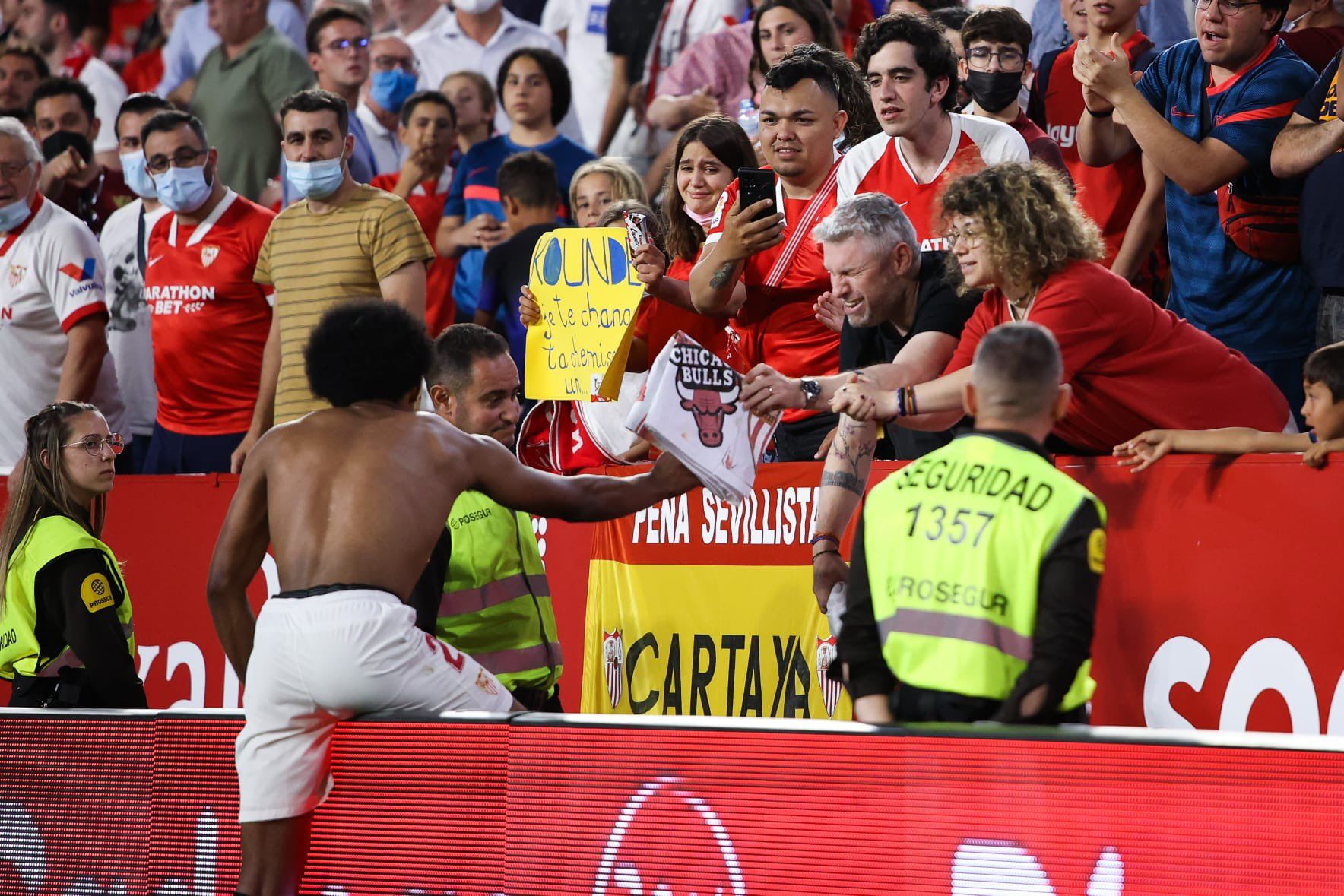 Jules Koundé, entregando una camiseta a unos aficionados del Sevilla.