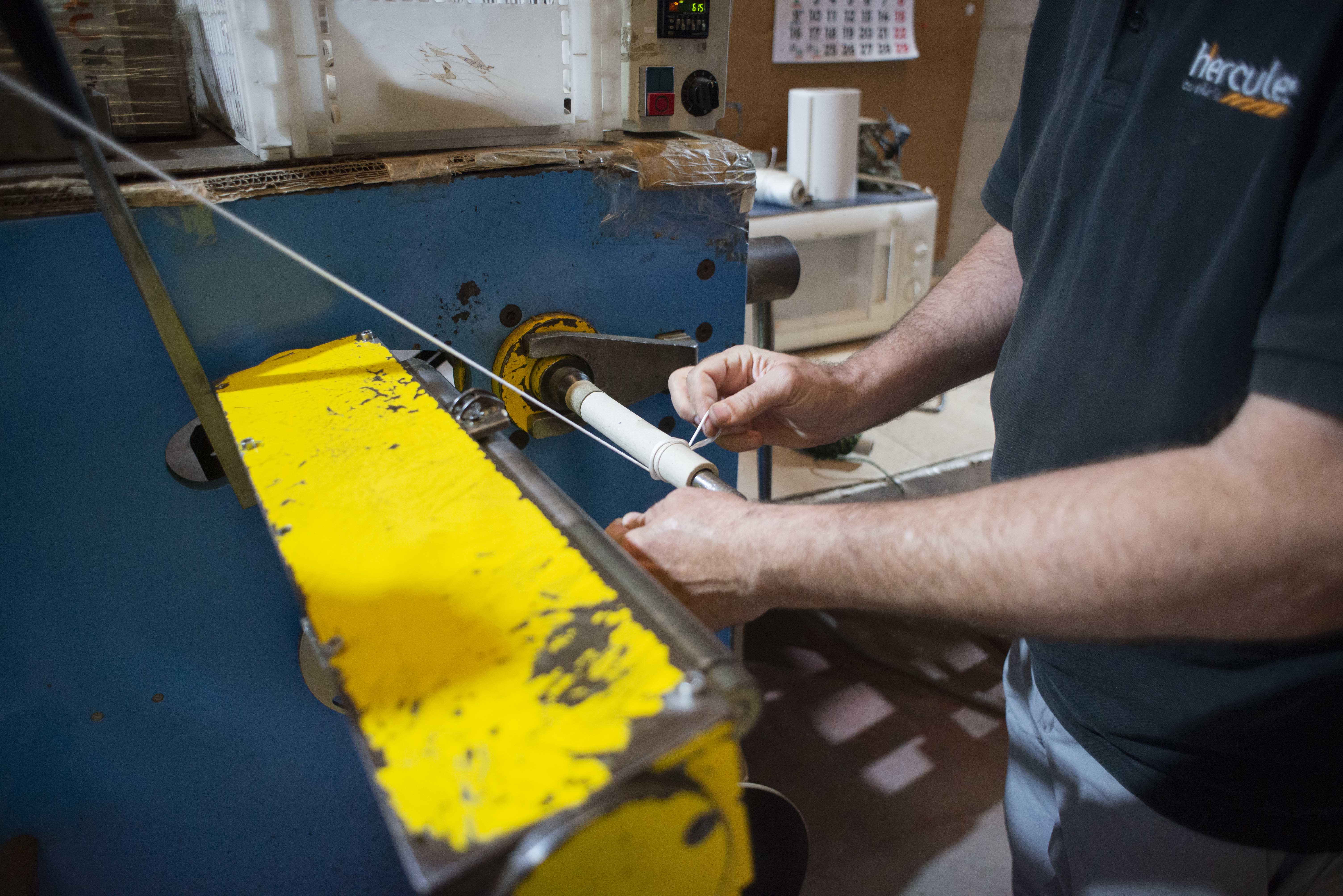 Antonio colocando el hilo en la fábrica.