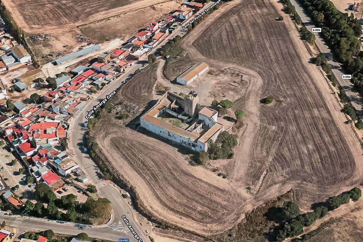 El castillo de Torremelgarejo y el entorno de la barriada rural donde se cree que está la fosa de asesinados por el franquismo.