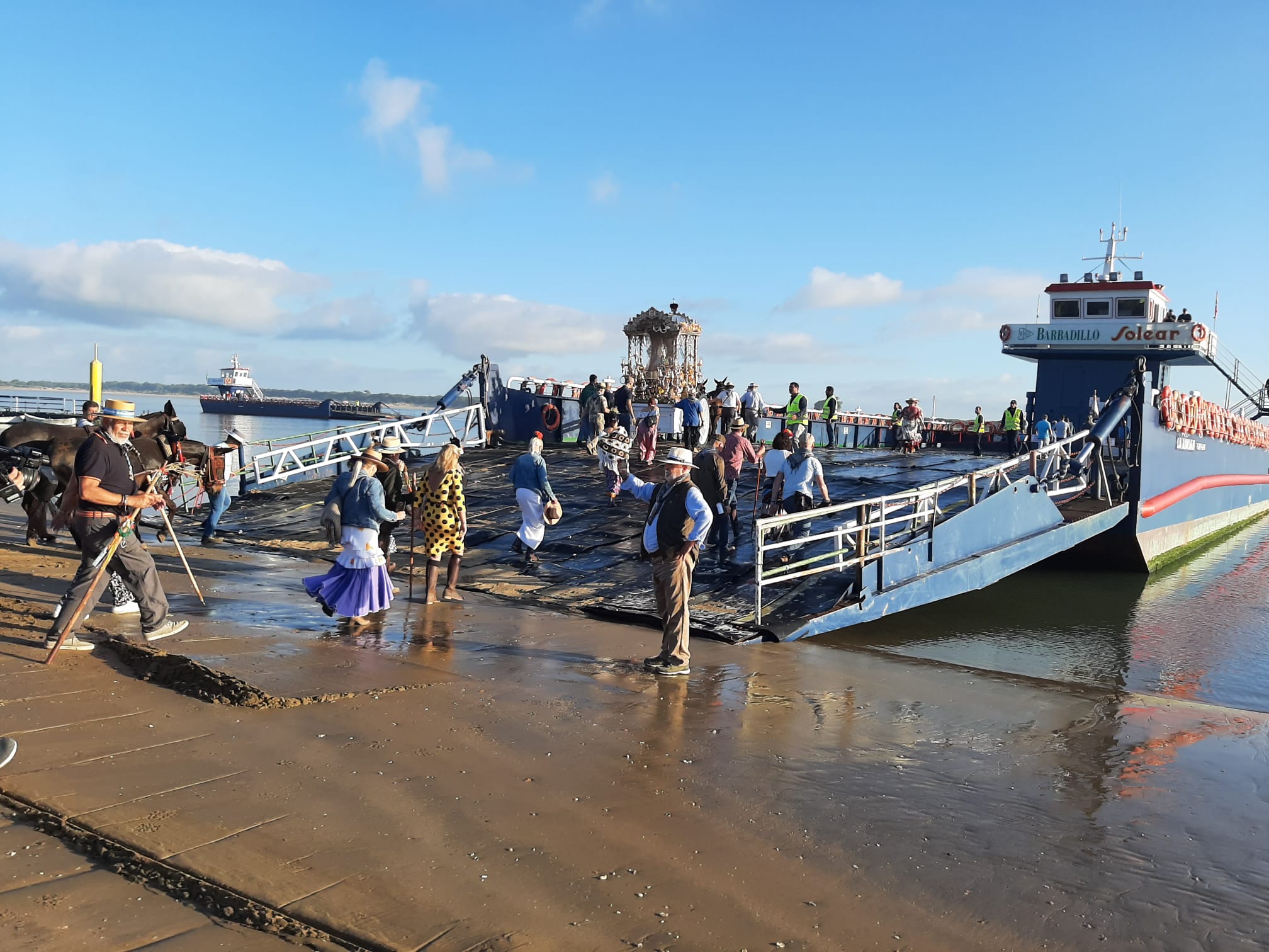 El simpecado de la Hermandad de la Linea, esta mañana, entrando en la barcaza para cruzar hacia Doñana.