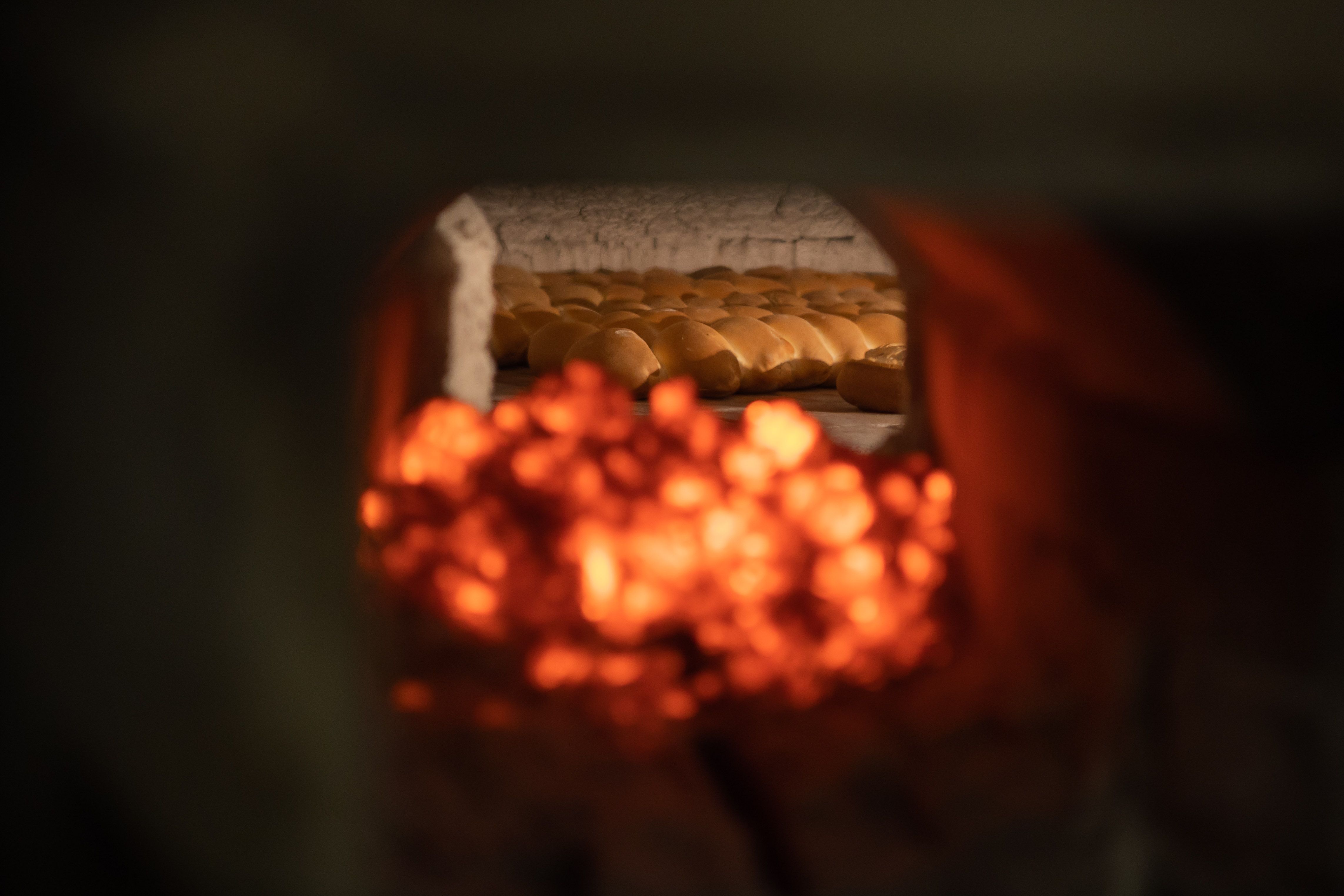 Leña de eucalipto rojo virgen en el horno de tiro directo de la panadería El Portal