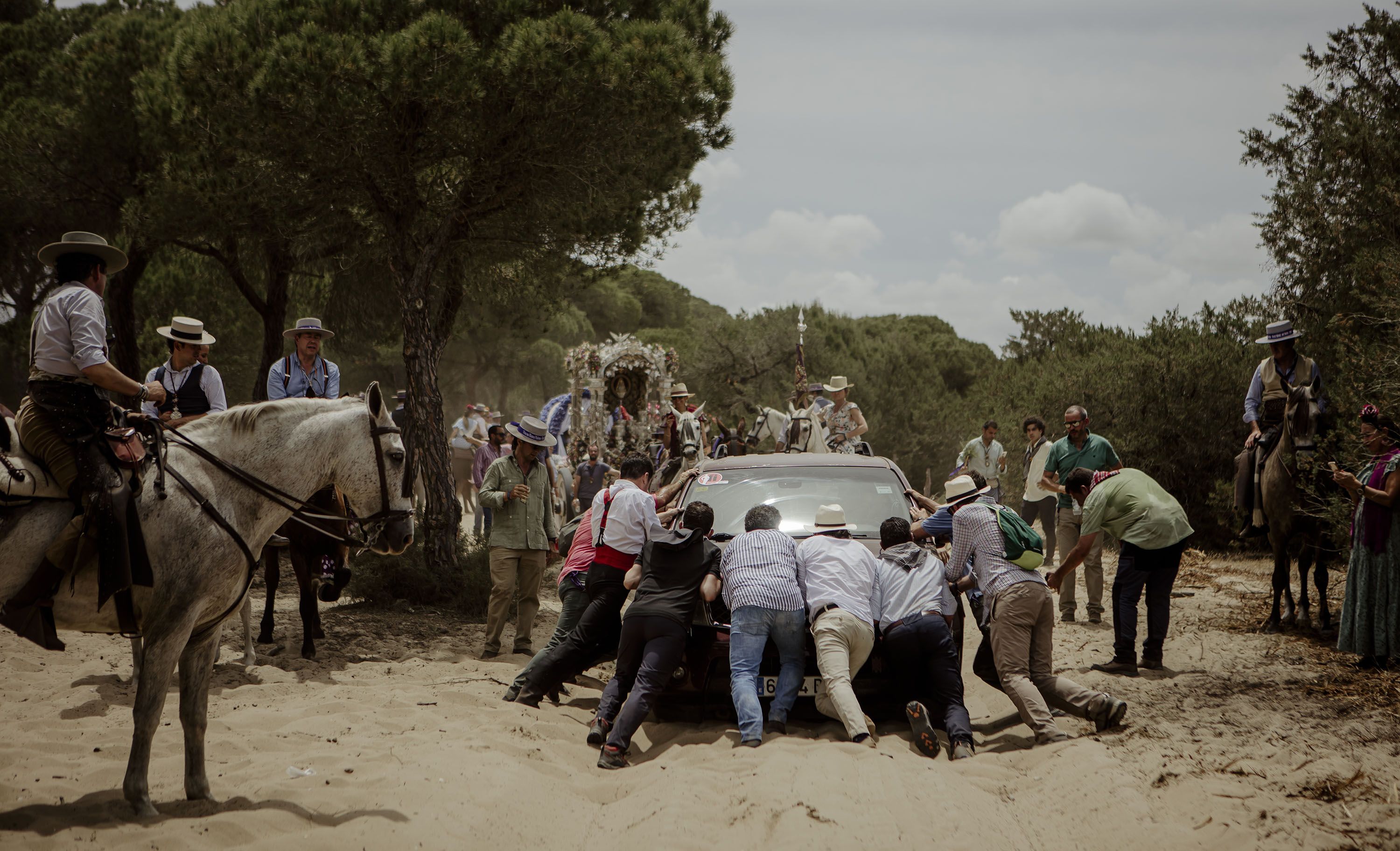 Toda ayuda es poca; rocieros empujando un todoterreno que quedó atrapado en las arenas- Toda ayuda es poca; rocieros empujando un todoterreno que quedó atrapado en las arenas-