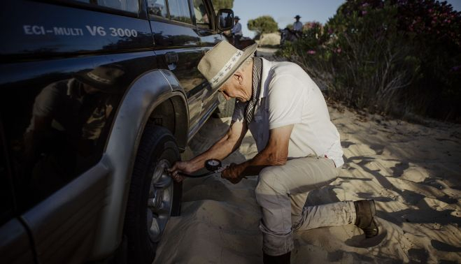 El mecánico y rociero Pepe Veiro asistiendo a un todoterreno en el sendero.   ESTEBAN