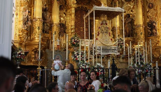 La Virgen del Rocío en su paso dentro de la ermita mientras cientos de romeros jerezanos se apostaban en la reja tras presentarse la hermandad.   MANU GARCÍA 