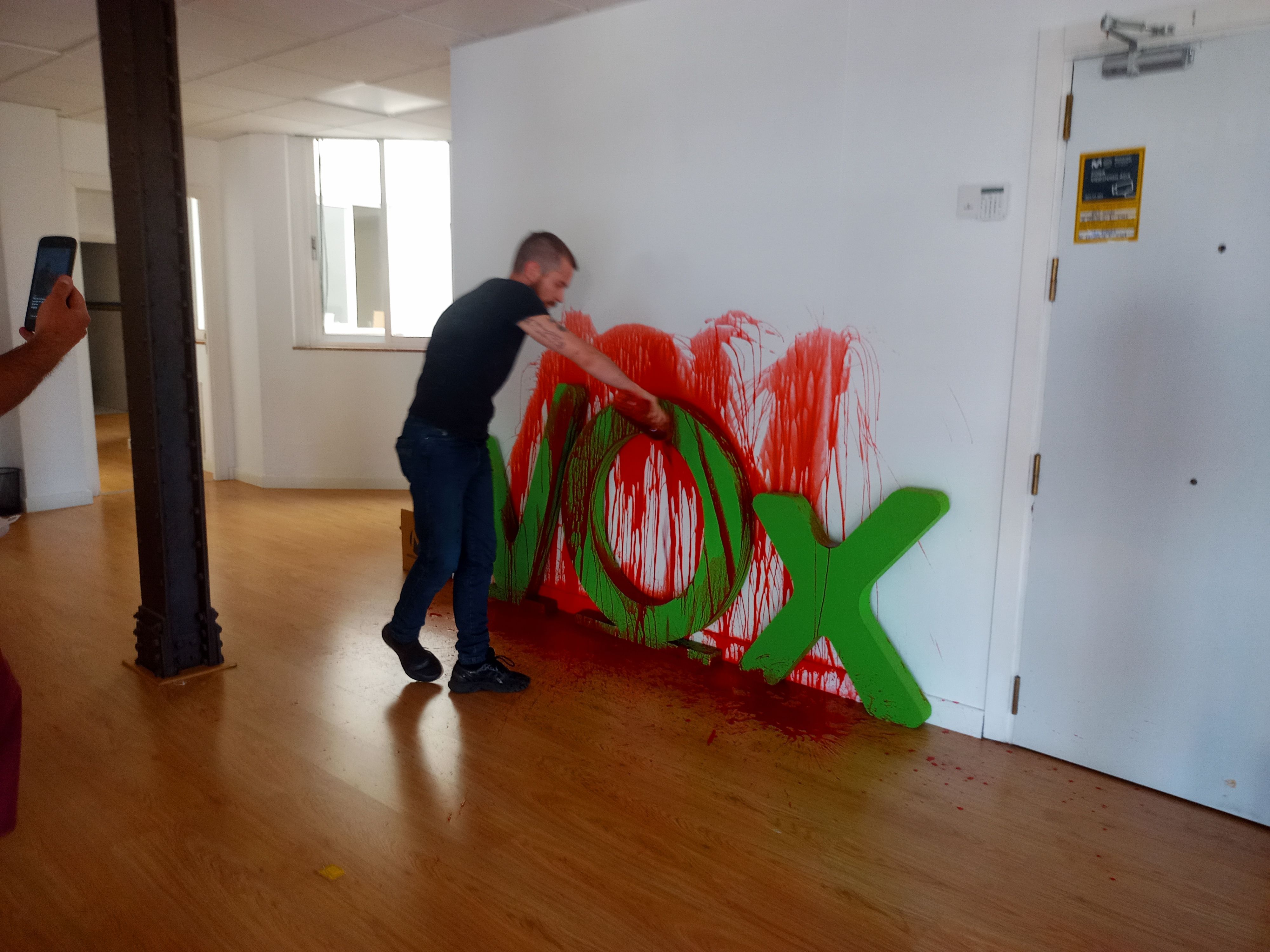 Uno de los activistas pintando la sede de Vox
