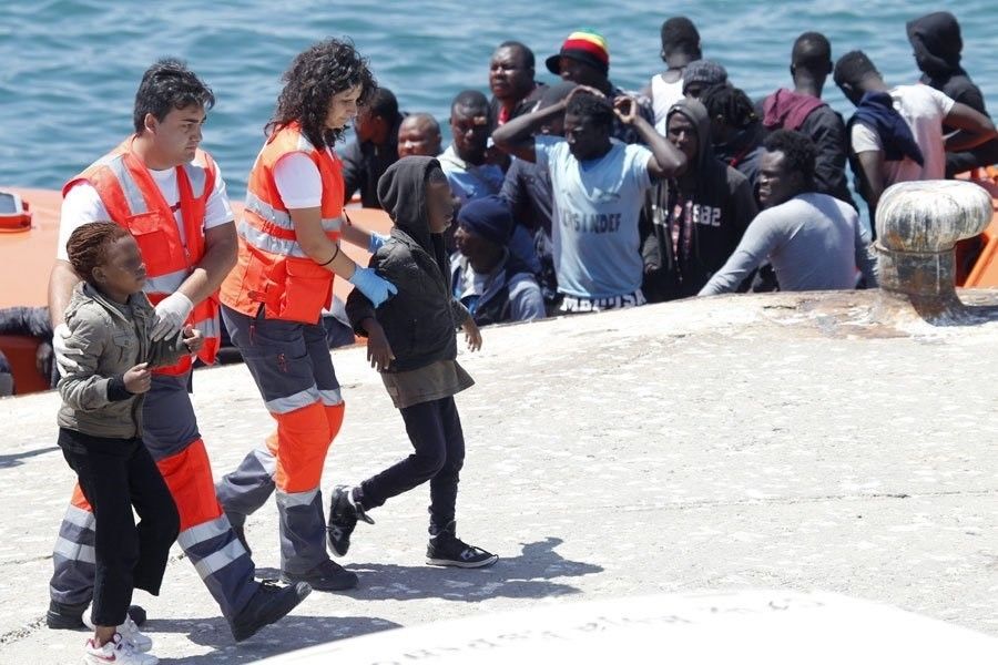 Técnicos de Cruz Roja acompañando a menores tras llegar en patera a las costas gaditanas, en una imagen de archivo. FOTO: JUNTA DE ANDALUCÍA. 