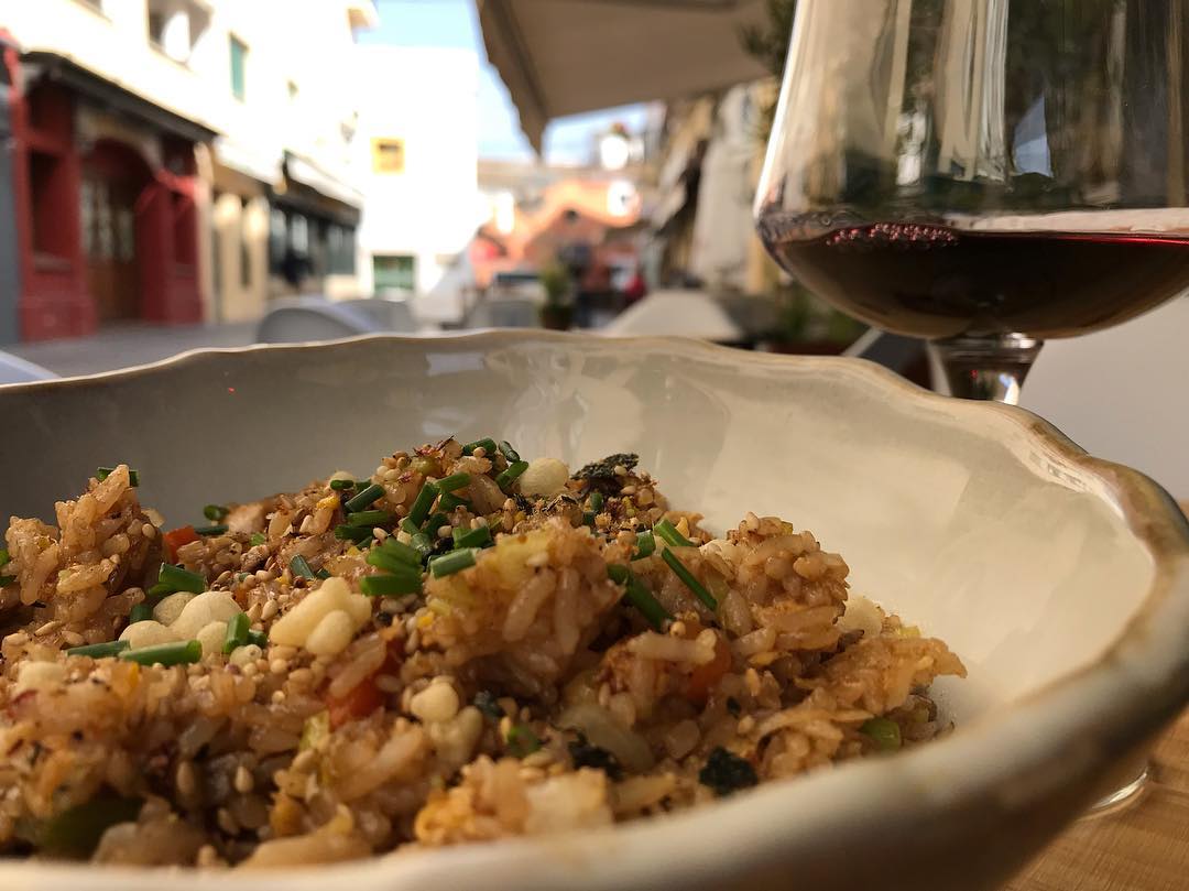 Un playo de toriyakimesi, arroz salteado japonés de pollo, con una copa de vino en Dhoma. FOTO: DHOMA RESTAURANTE. 