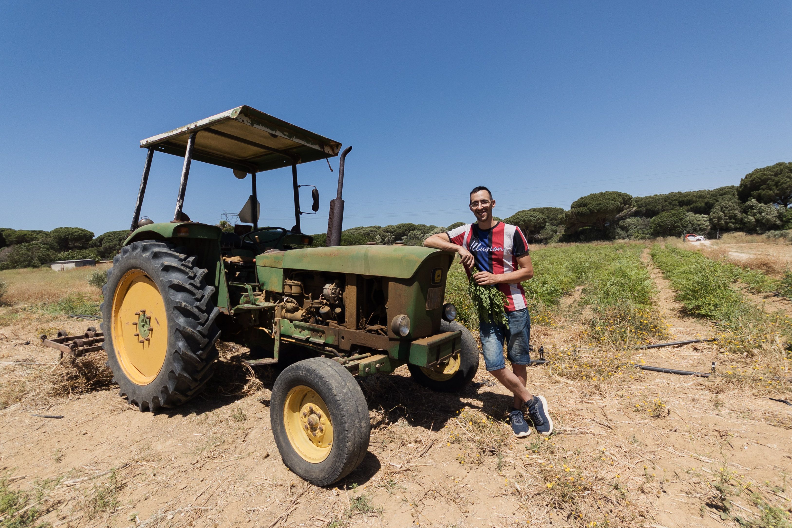Alberto junto al tractor que utilizan para el trabajo en la finca.