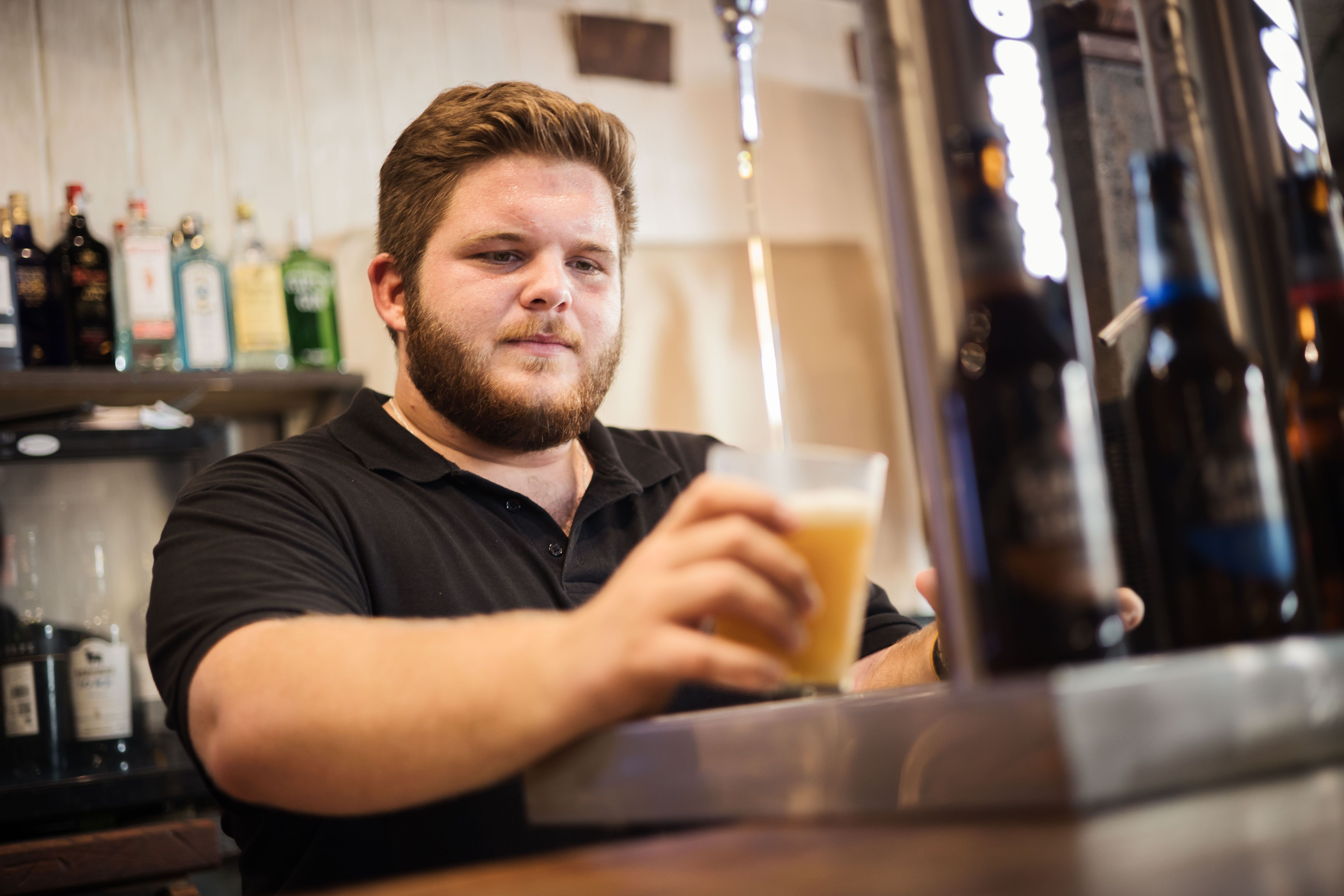 Alberto sirve cerveza desde la barra de La Abadía.