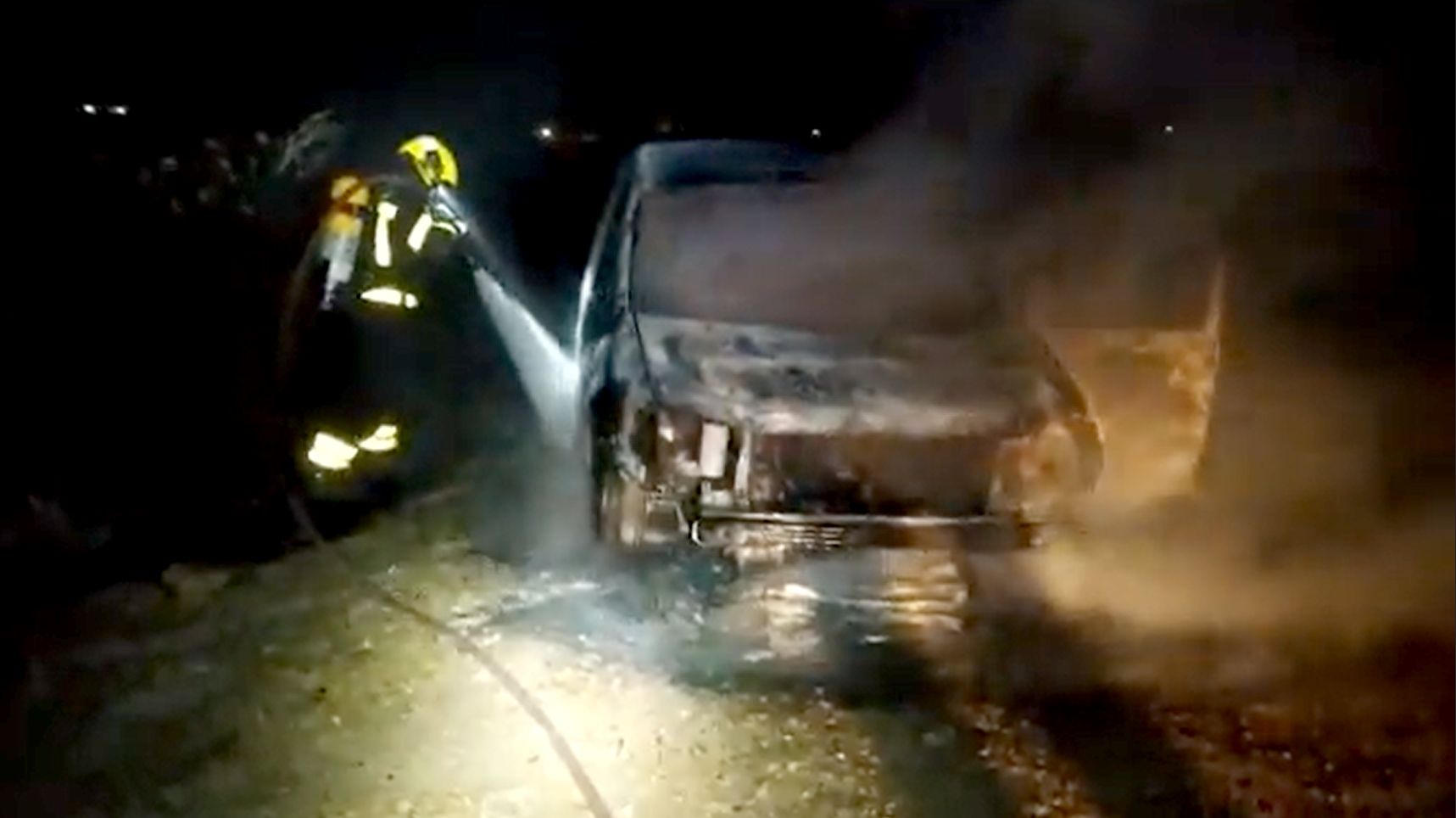 Bomberos en las labores de extinción de un incendio en un coche en una imagen de archivo.  