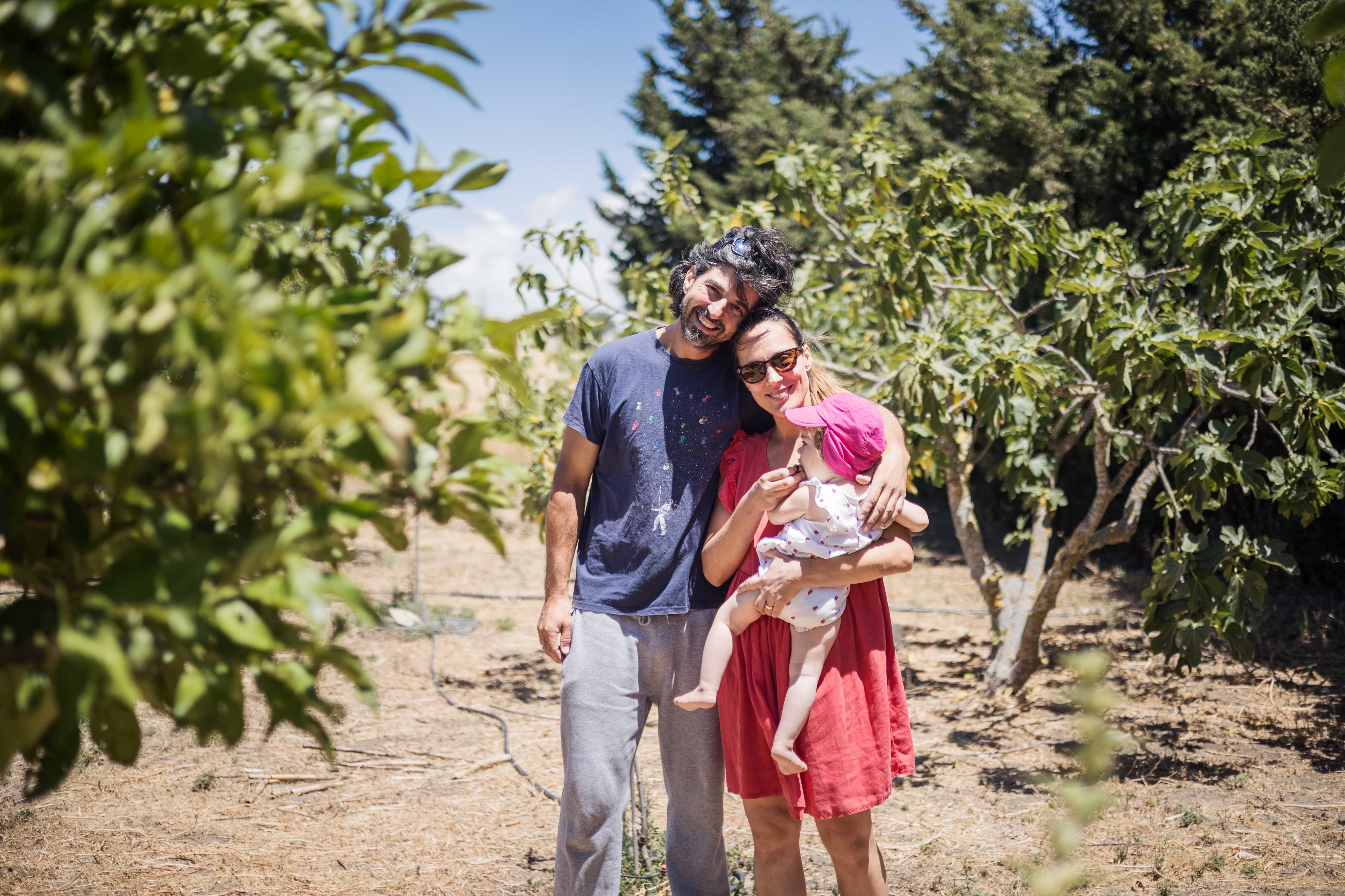 Marko y Natasa Simic con su hija Lara en el bosque comestible que han diseñado en su finca de Puerto Real.