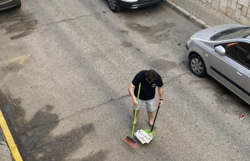 Un vecino limpiando una calle en Sevilla.