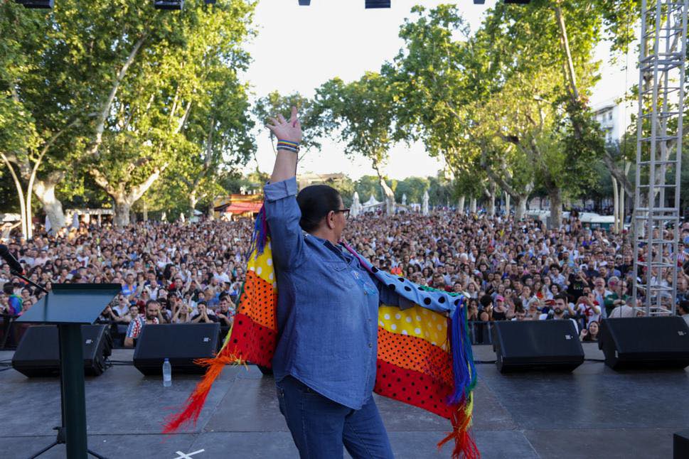 María del Monte, bailando con una bandera LGTBI con lunares en el Orgullo de Sevilla.