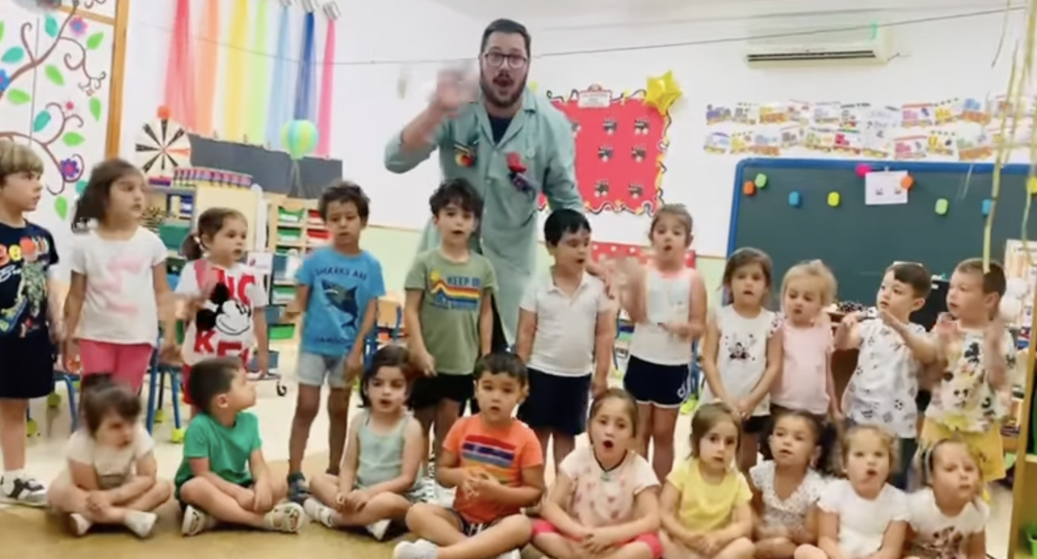 Alejandro Sanz responde al maestro Alberto junto a sus alumnos y alumnas de Infantil en el CEIP Juan Armario de Alcalá de los Gazules.