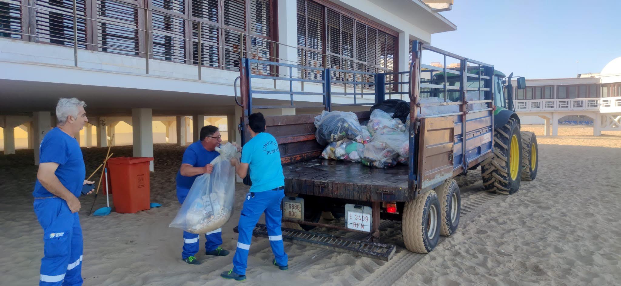 Operarios de limpieza trabajando en la playa de la Caleta.
