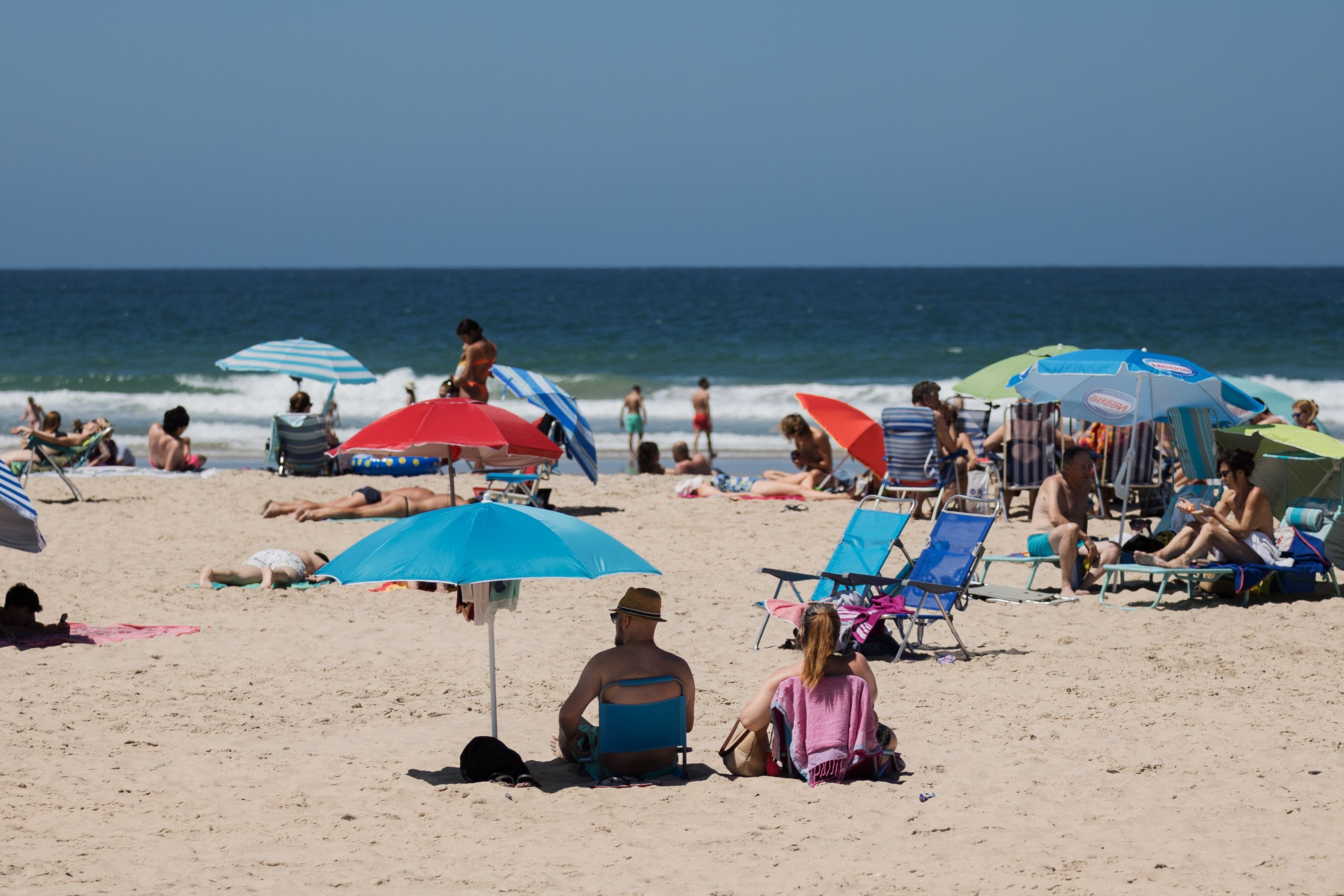 Varias personas disfrutando de una de las mejores playas de Andalucía, en Conil.
