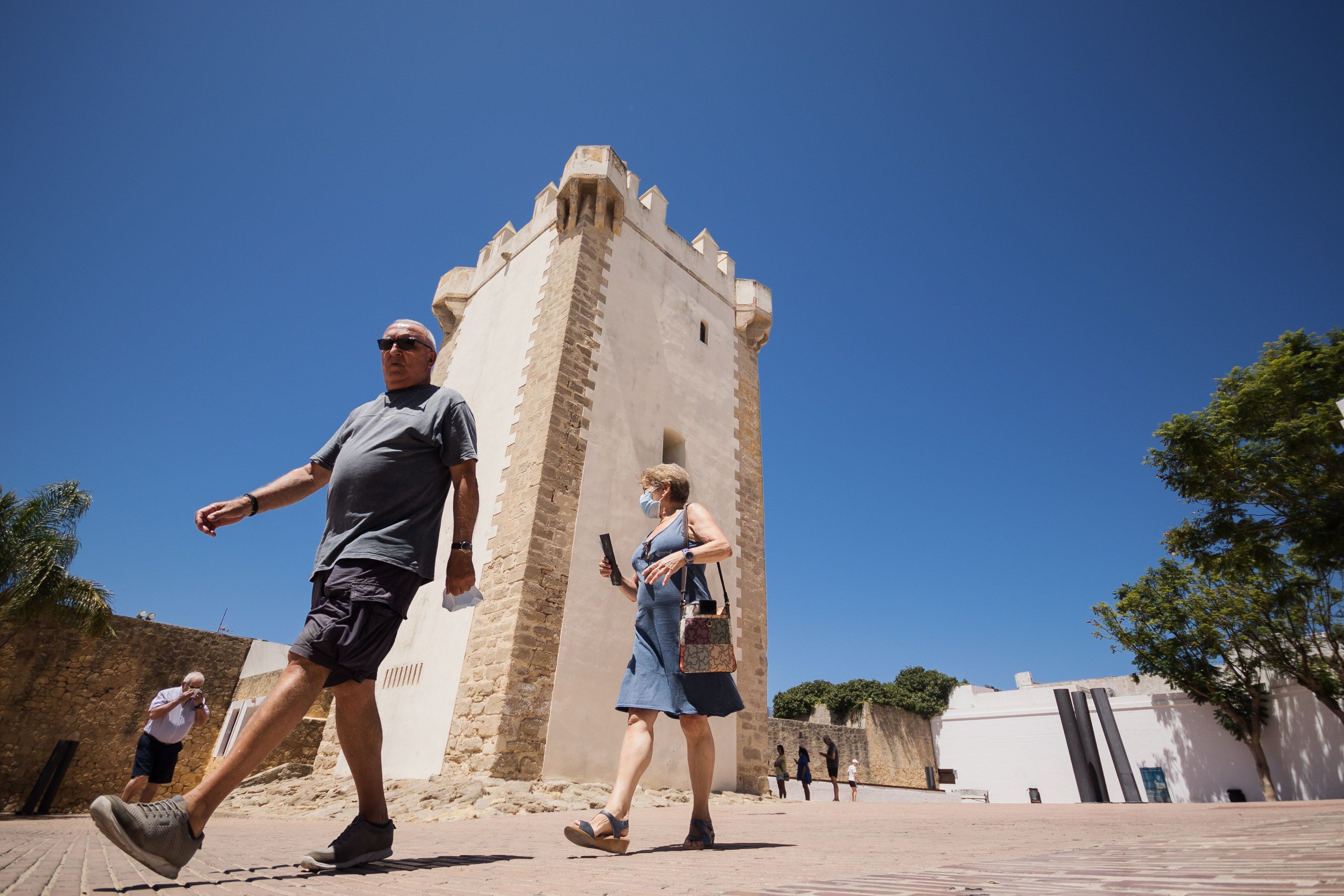 Dos turistas pasean por Conil, uno de los mejores lugares de la provincia de Cádiz para escapar de las temperaturas extremas.