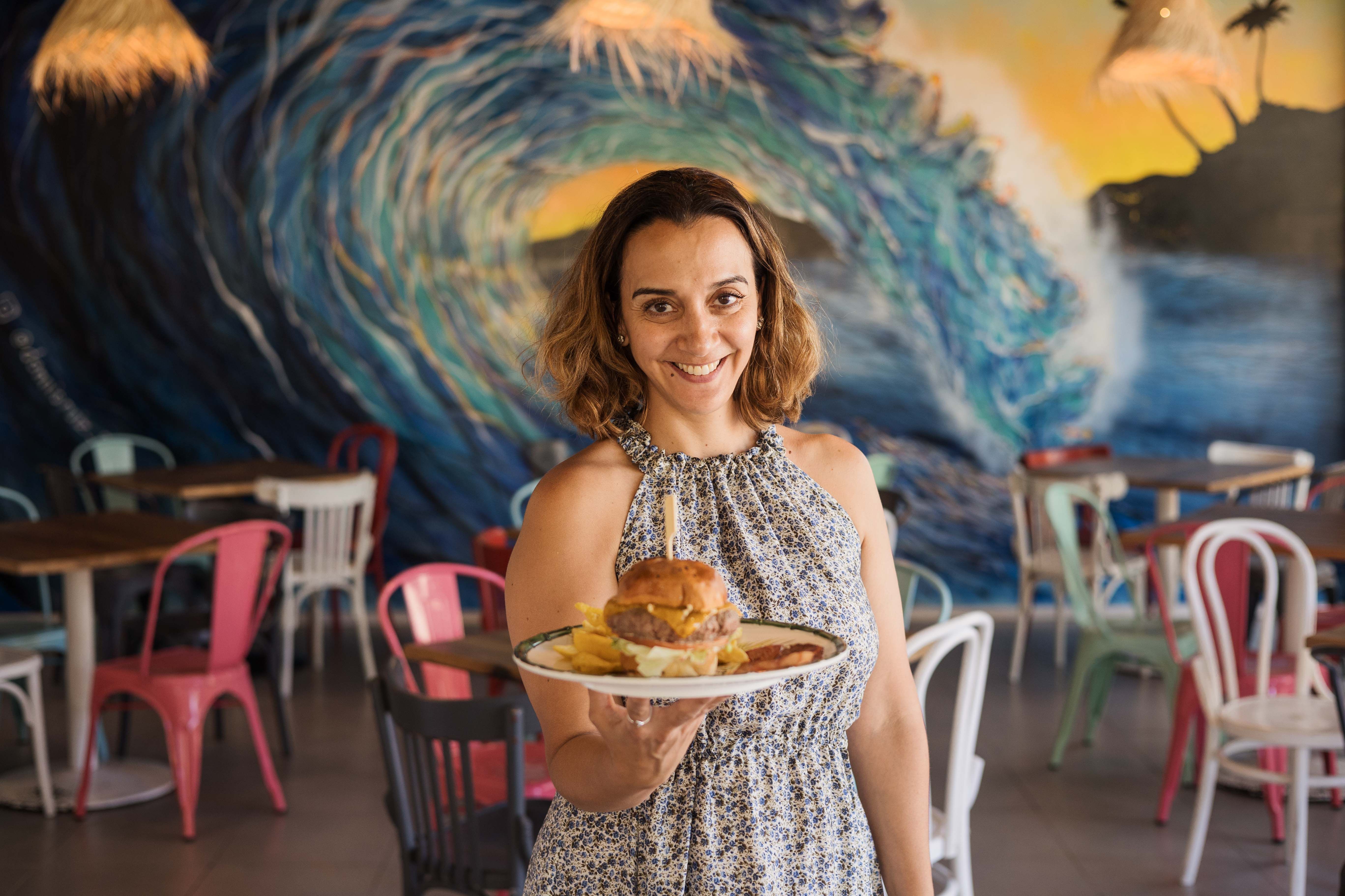 La madrileña Vanesa Hervías con una hamburguesa de ternera de la sierra de Guadarrama en The Surf House Café, en El Puerto.