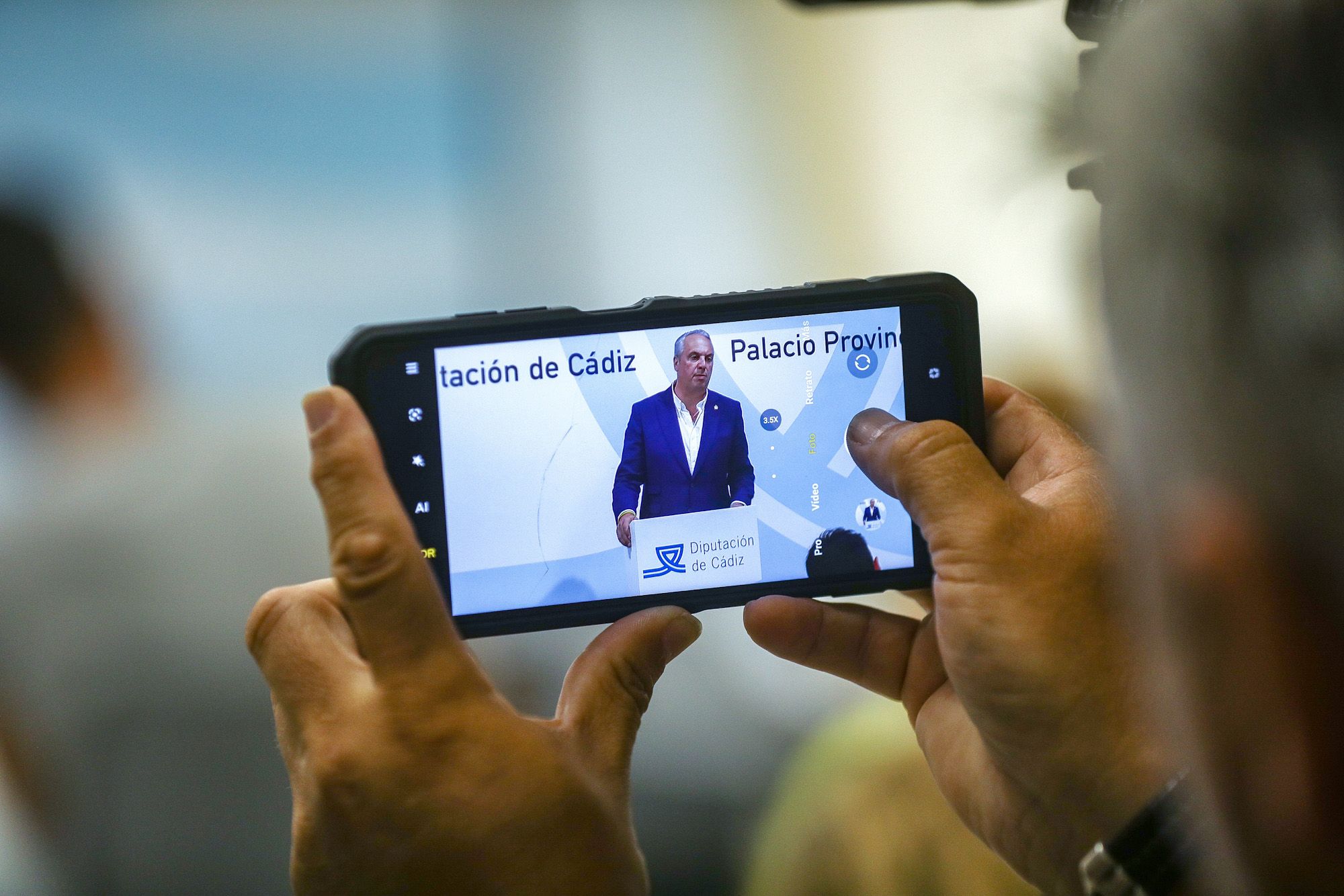 Un asistente a la rueda de prensa del nuevo presidente de Diputación de Cádiz, Juan Carlos Ruiz Boix, graba con su móvil la intervención.