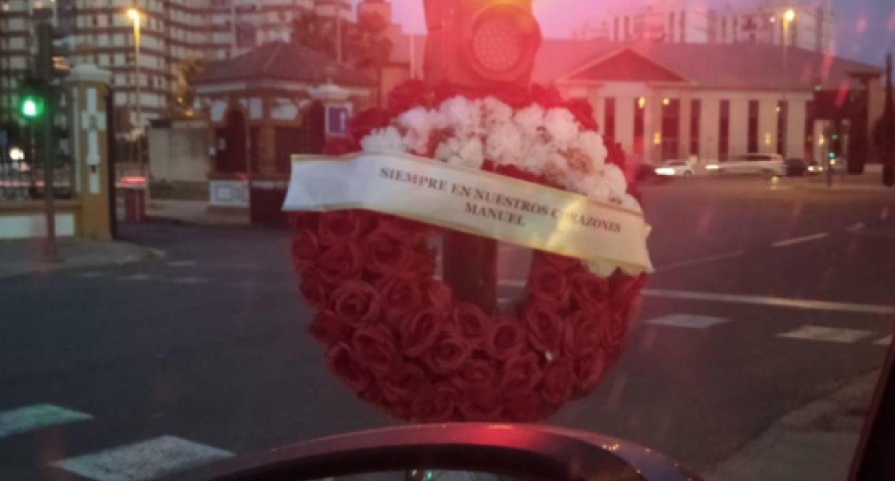 Una corona de flores en el semáforo en el que Manuel vendía pañuelos en Sevilla.