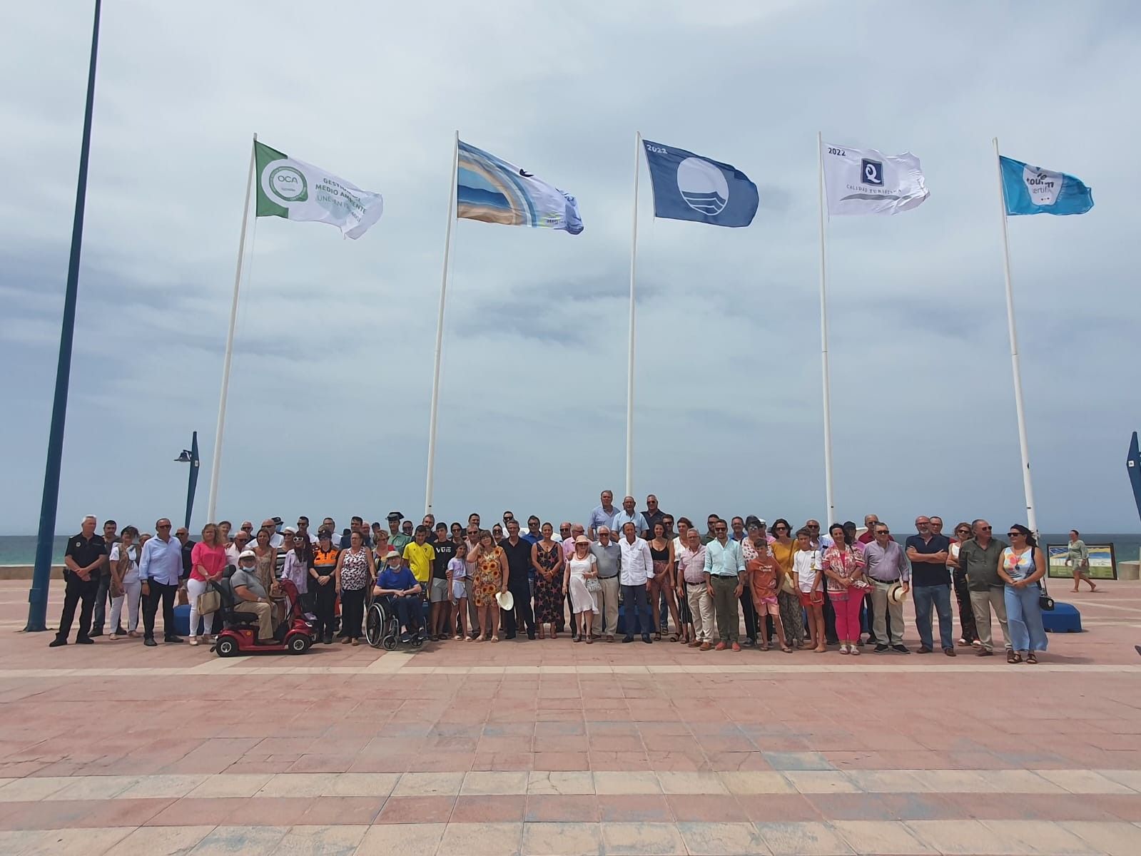 Imagen del izado de banderas en la playa de La Barrosa.