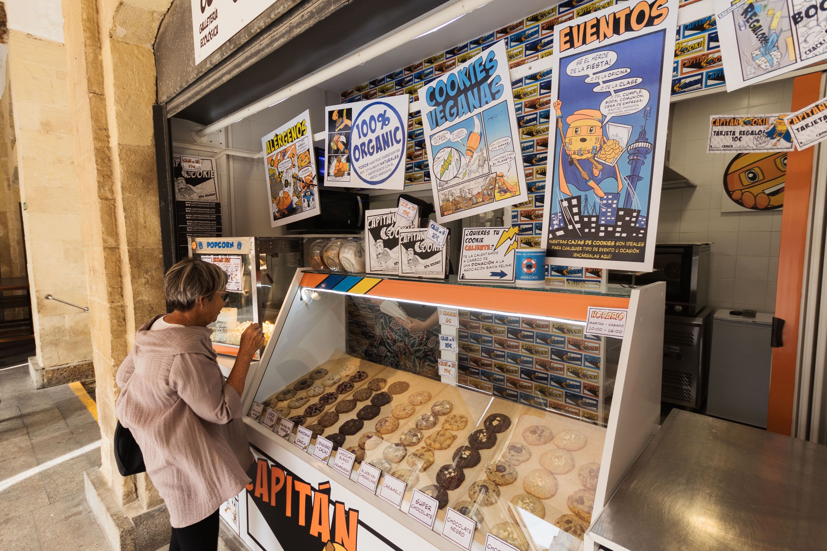 Una clienta elige las galletas del puesto del Mercado Central.