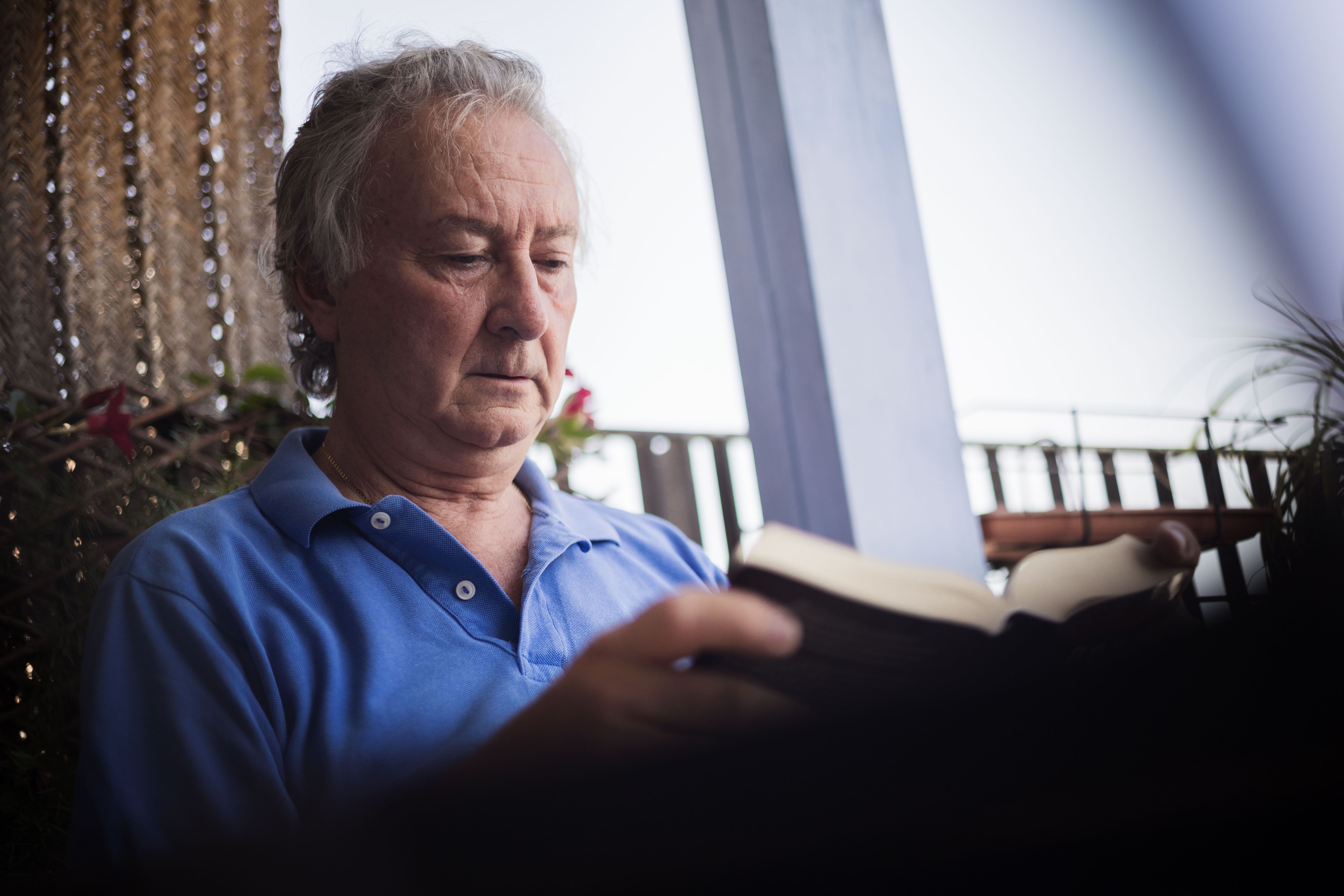 El entrevistado consultado uno de sus libros de la biblioteca que posee.    MANU GARCÍA