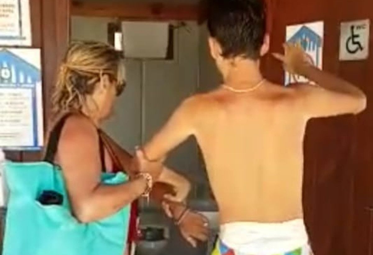 Victoria y su hijo en el módulo para personas con movilidad reducida de la playa de La Muralla, que no tiene ducha interna.  CEDIDA