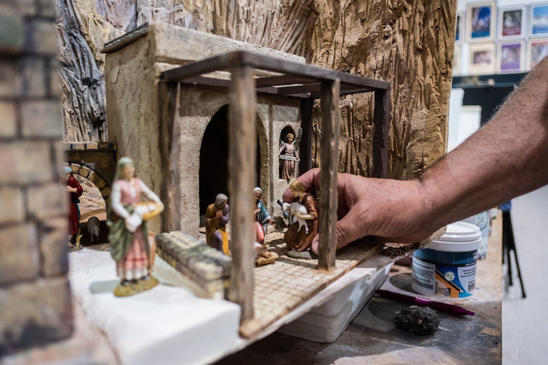Un belenista rematando el trabajo de creación de un diorama navideño.