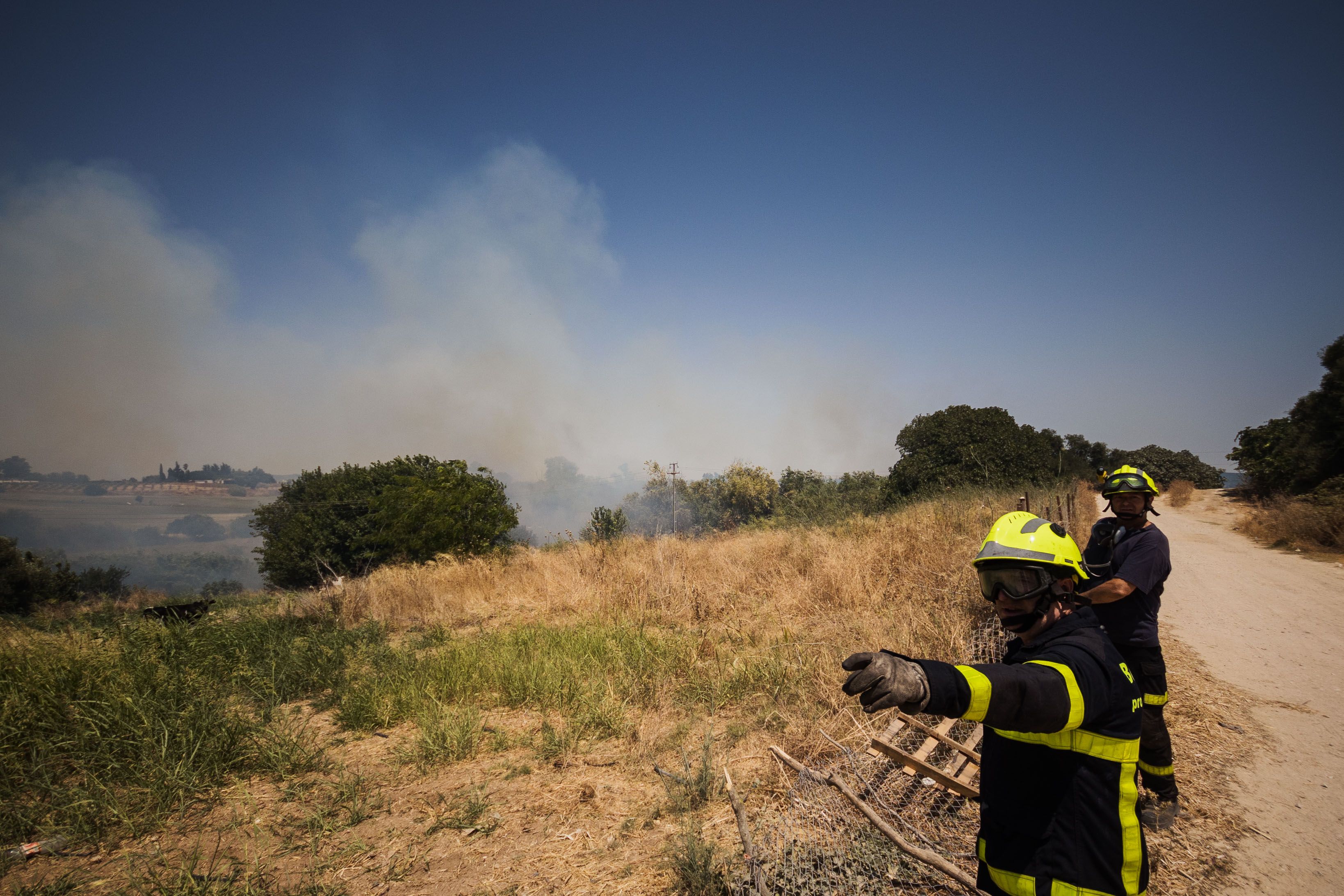 Un agente, indicando la dirección de las llamas.