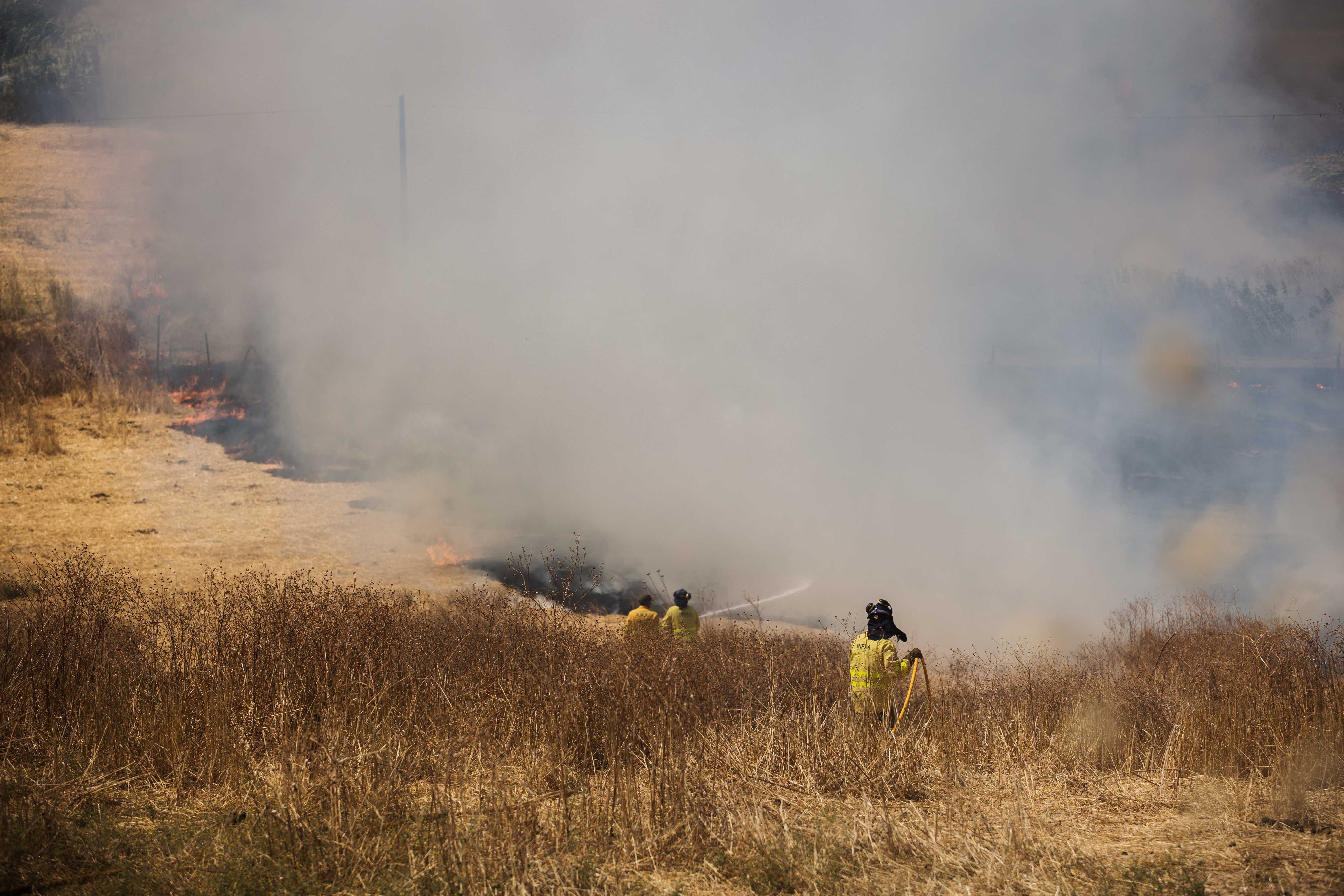 Bomberos trabajando intensamente en la extinción del incendio. 