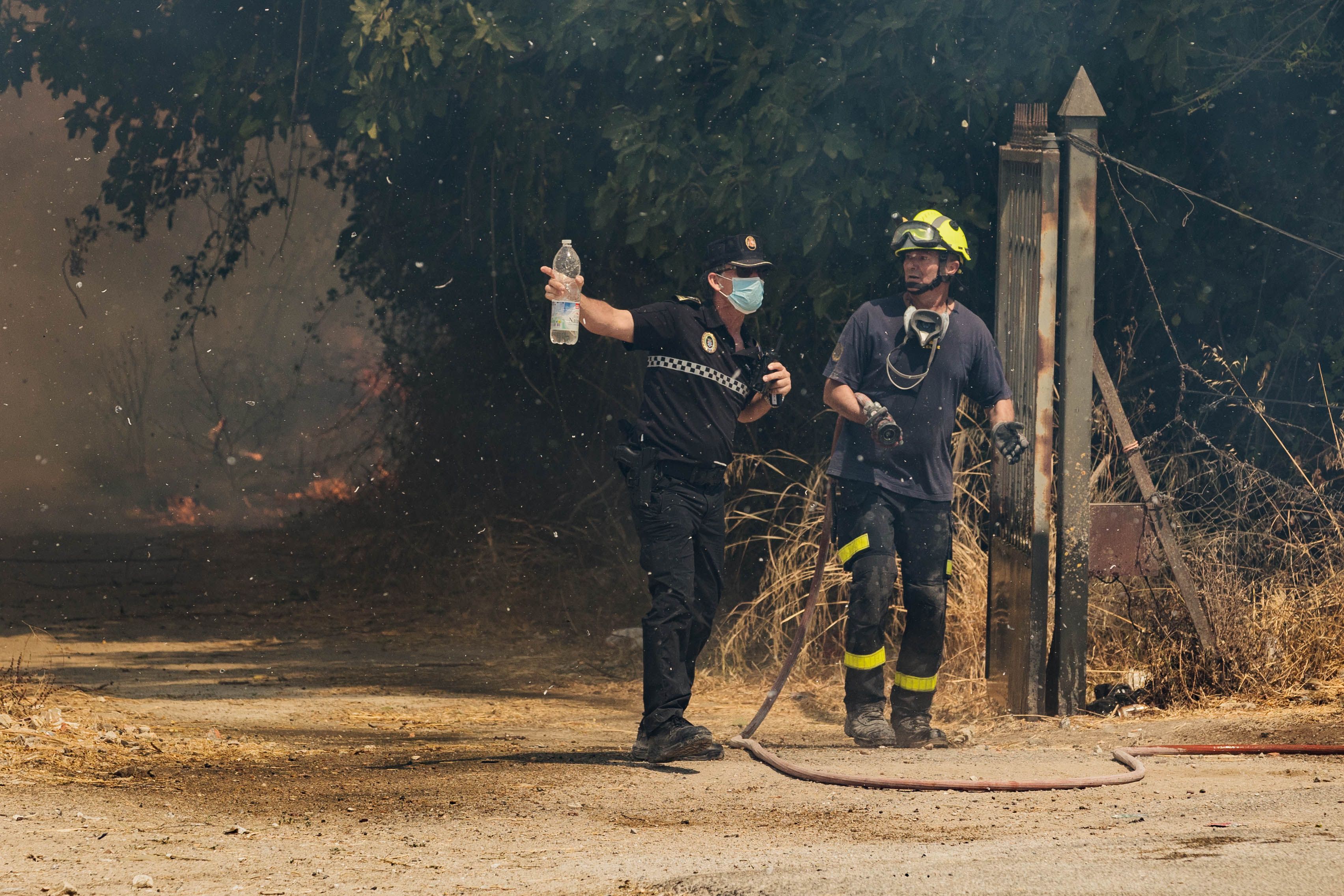 Un agente de la Policía Local dialoga con un bombero.