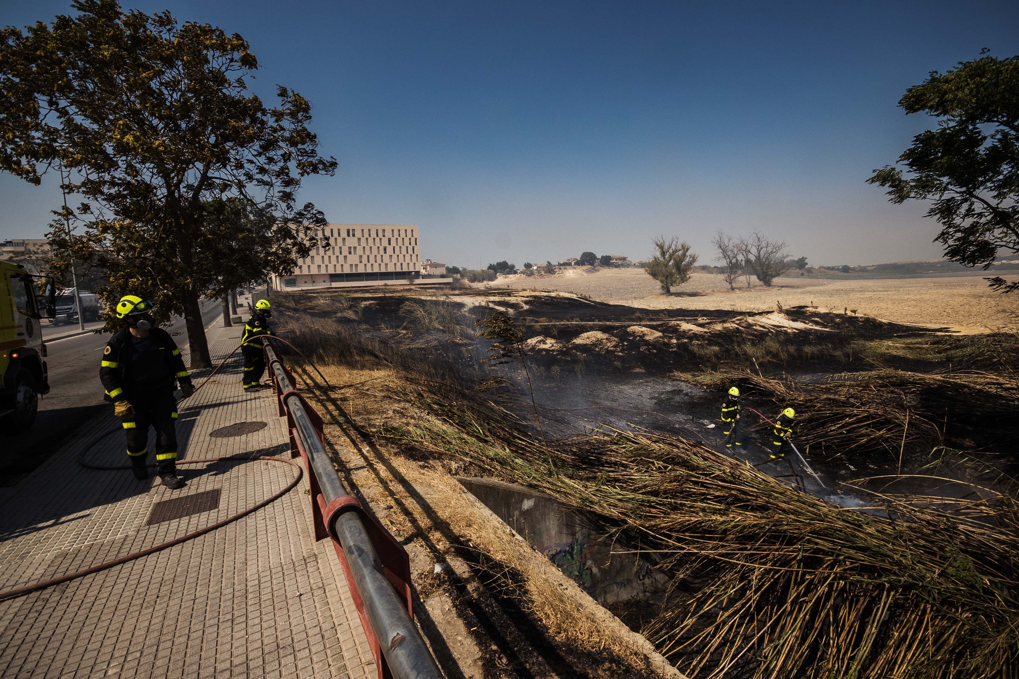 Bomberos intentando apagar uno de los focos del incendio.